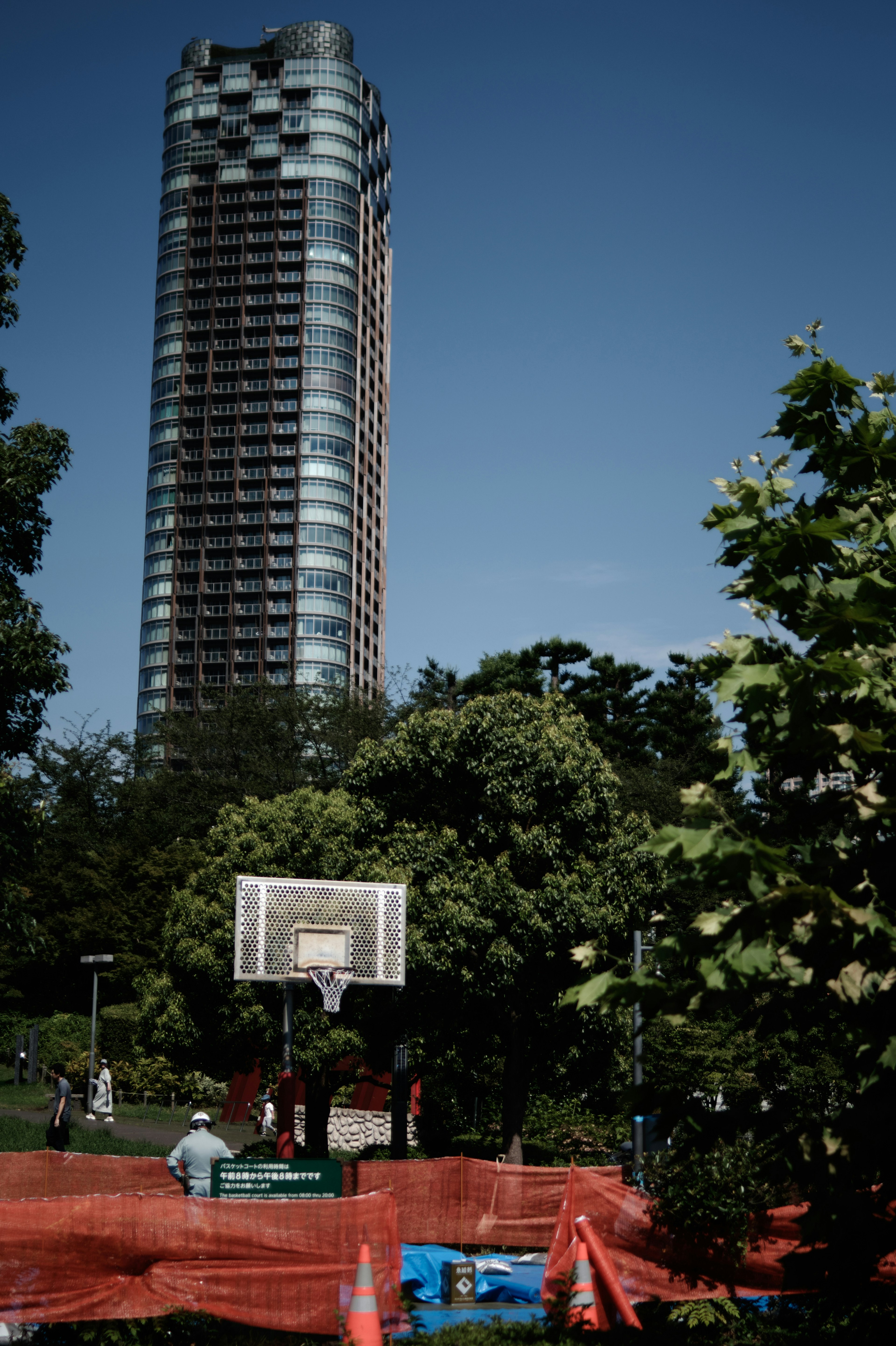 City park featuring a tall building and a basketball court