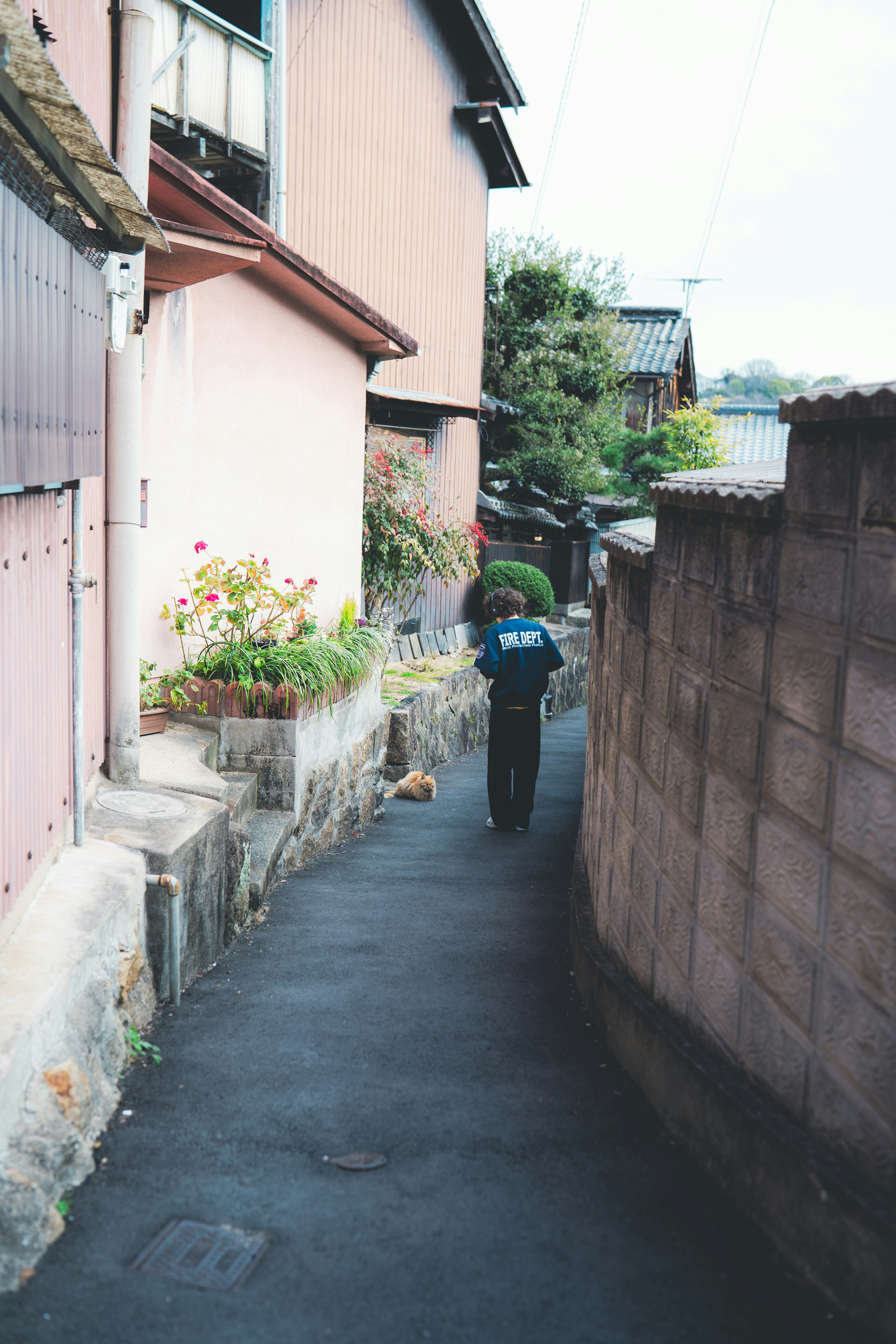 狭い路地を歩く人物と周囲の建物の風景