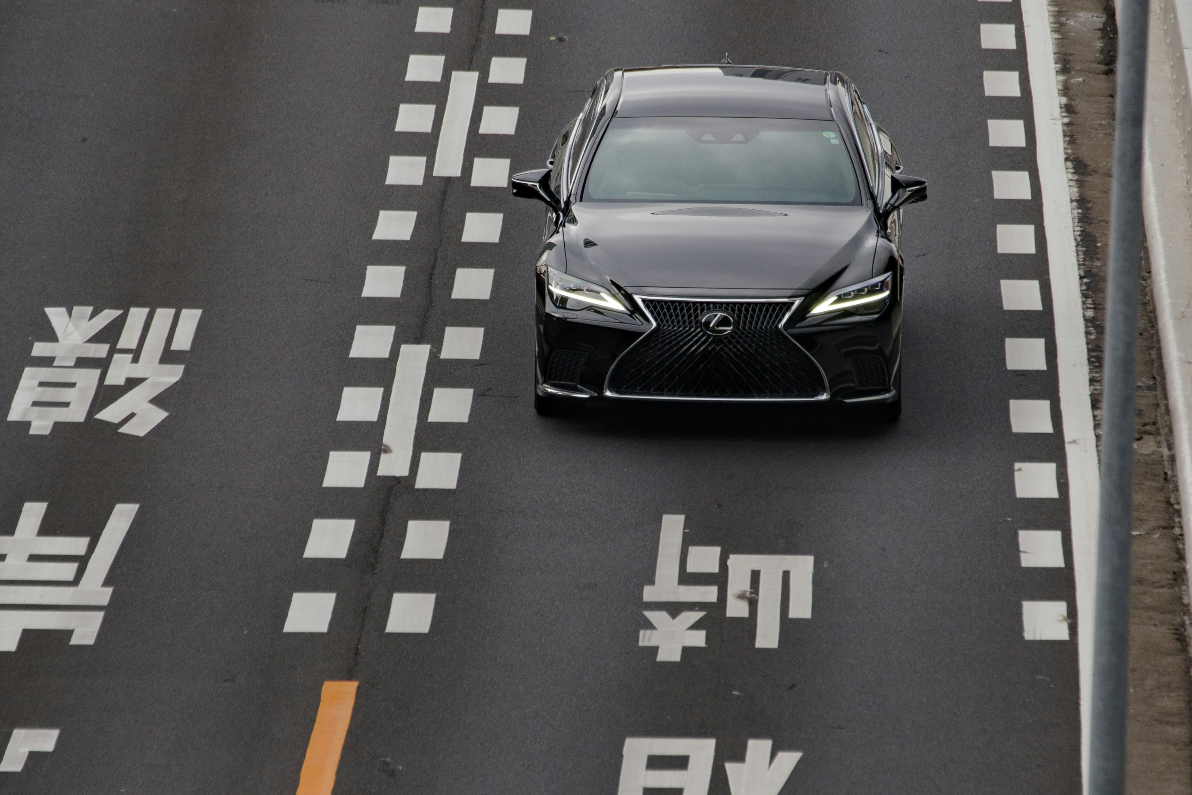 Une voiture noire circulant sur une autoroute avec des marquages de voie