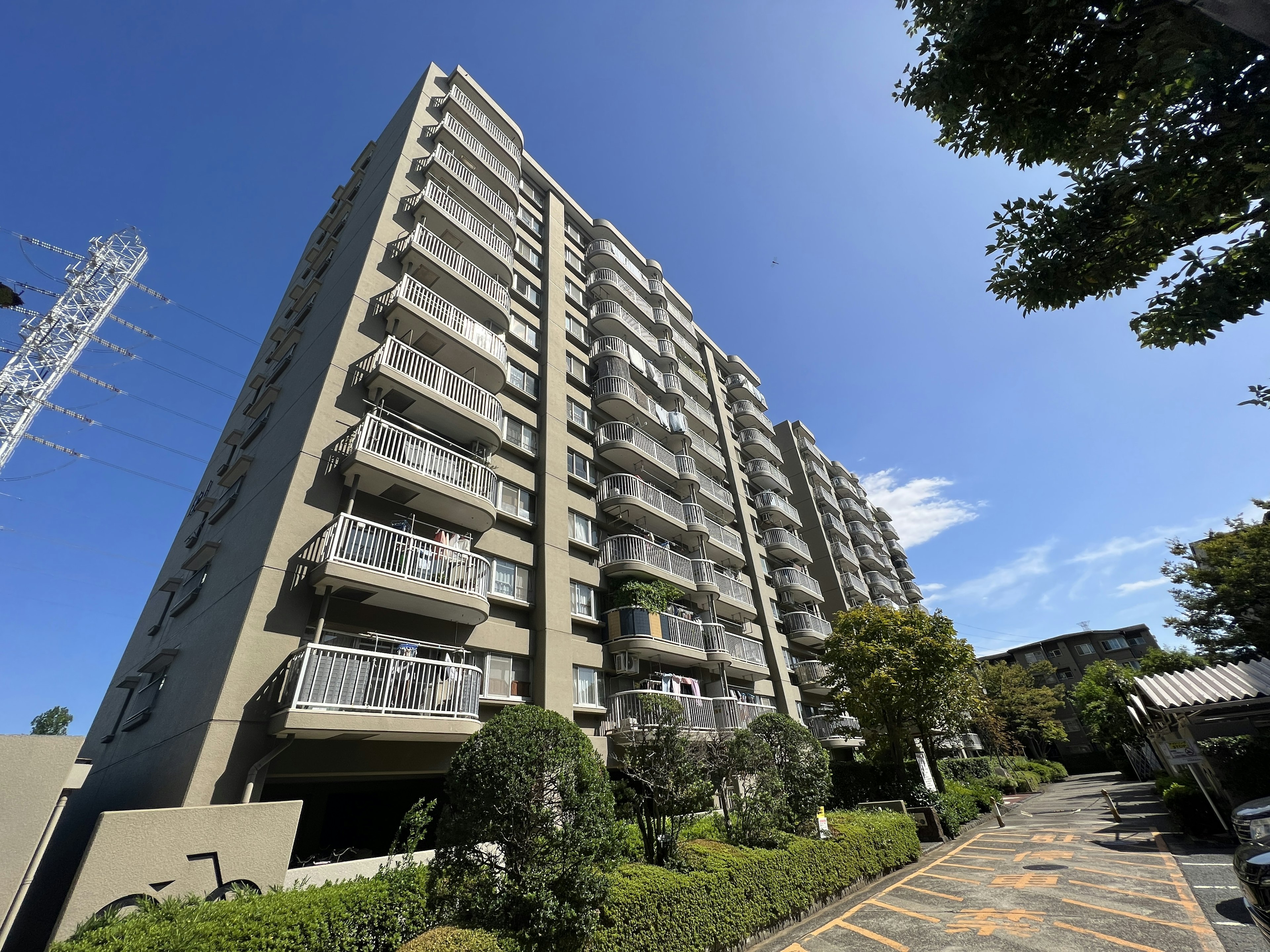 Exterior view of a high-rise apartment with greenery and blue sky