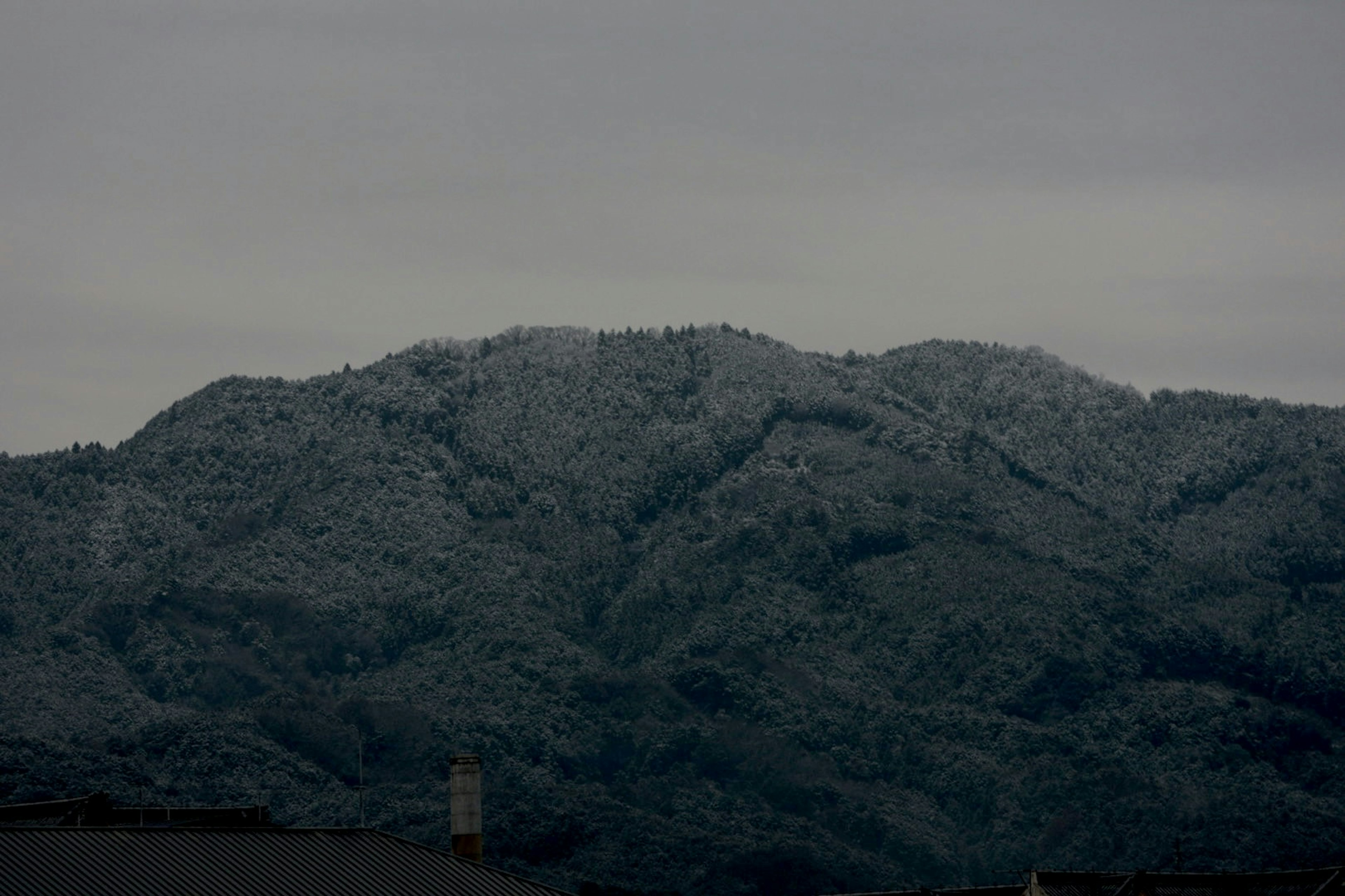 Snow-covered mountain landscape under a cloudy sky