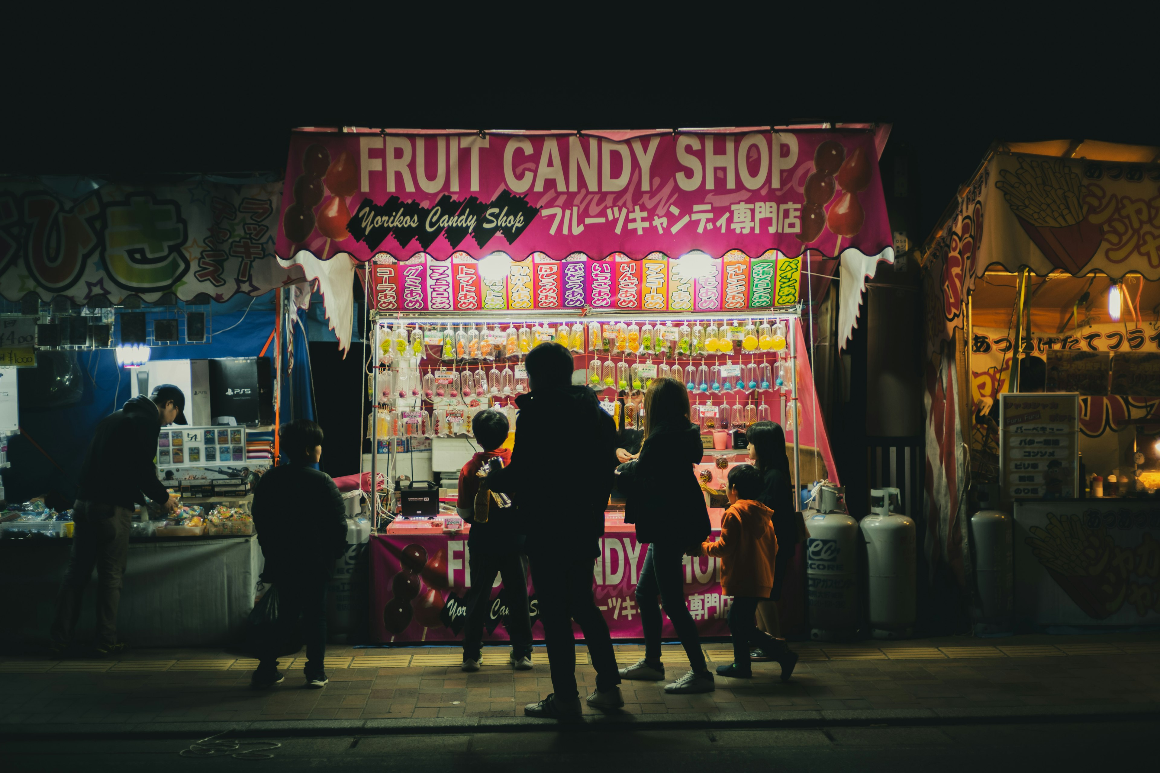 Colorato negozio di caramelle alla frutta illuminato di notte