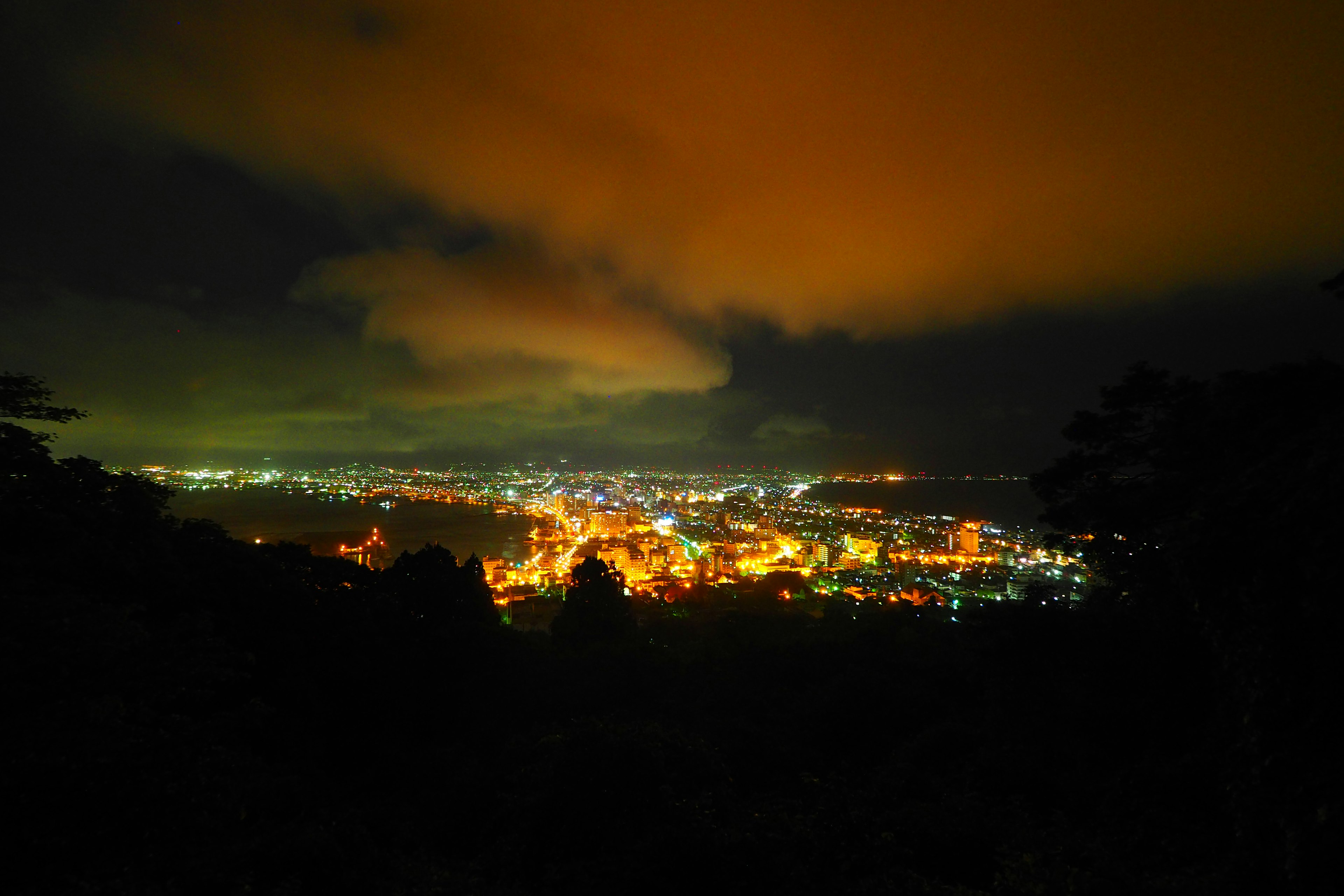 Vista nocturna de las luces de la ciudad con nubes en el cielo