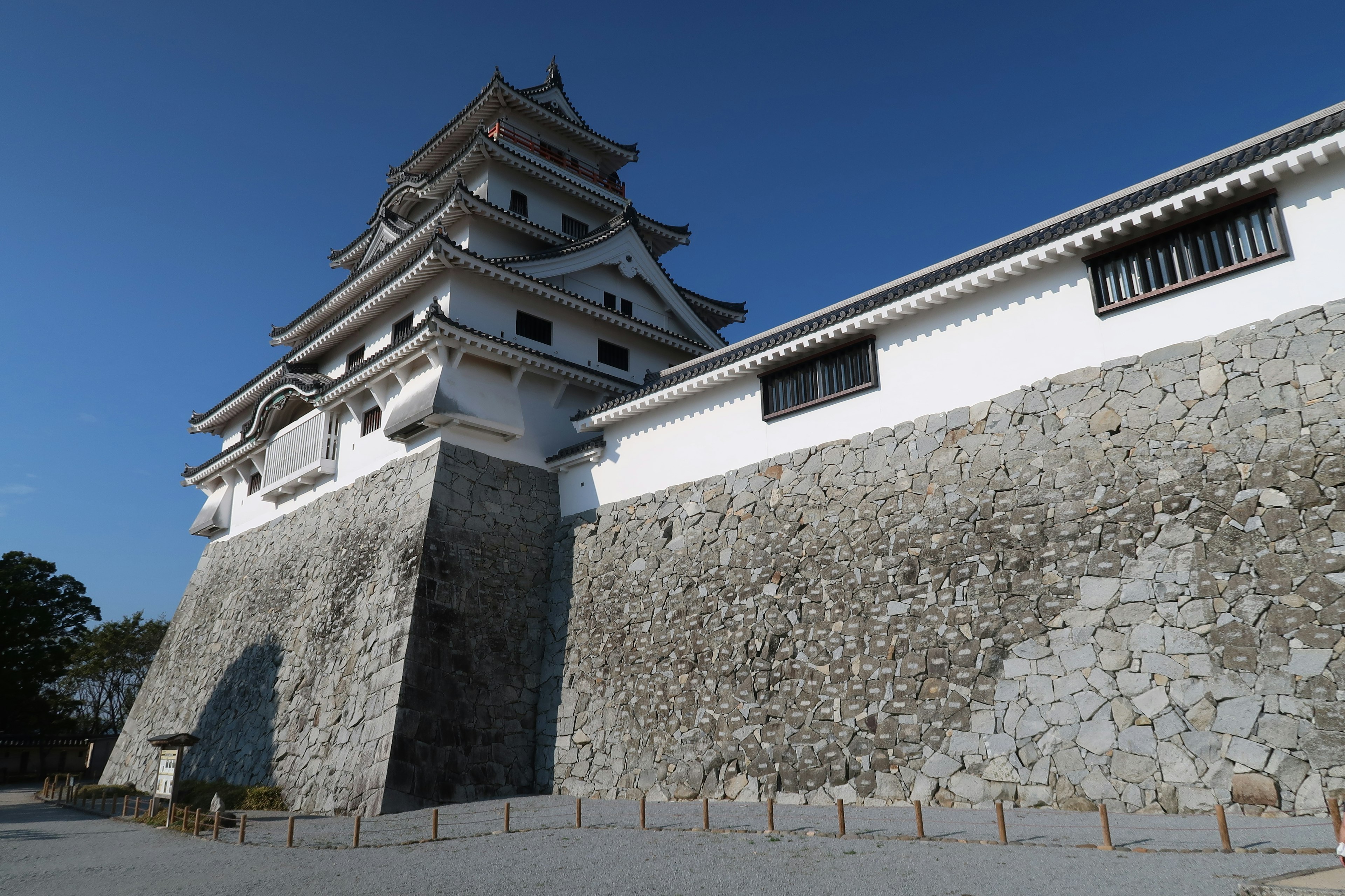 白い石垣と青空の下に立つ城の壮大な外観