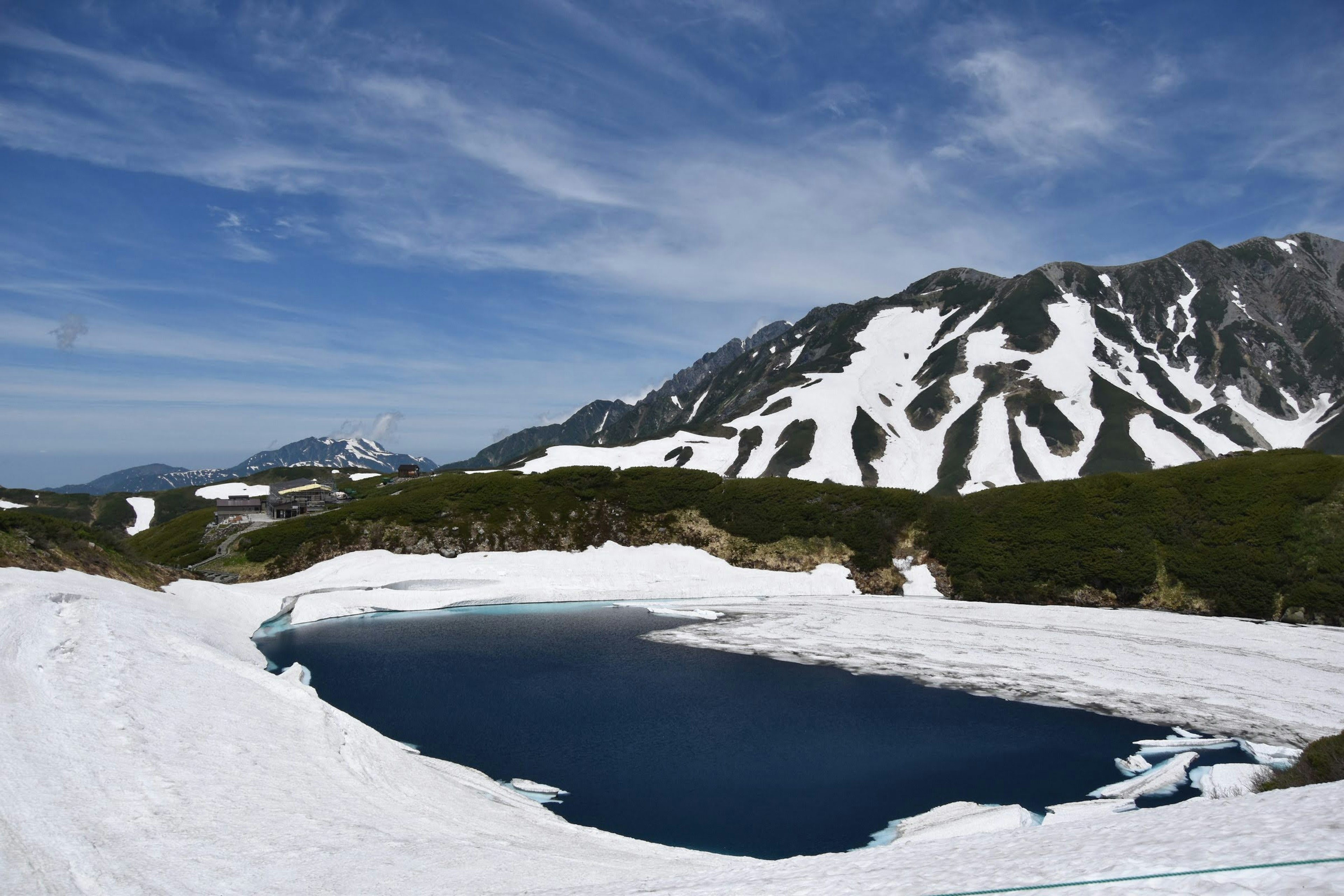 Montagne innevate con un lago blu