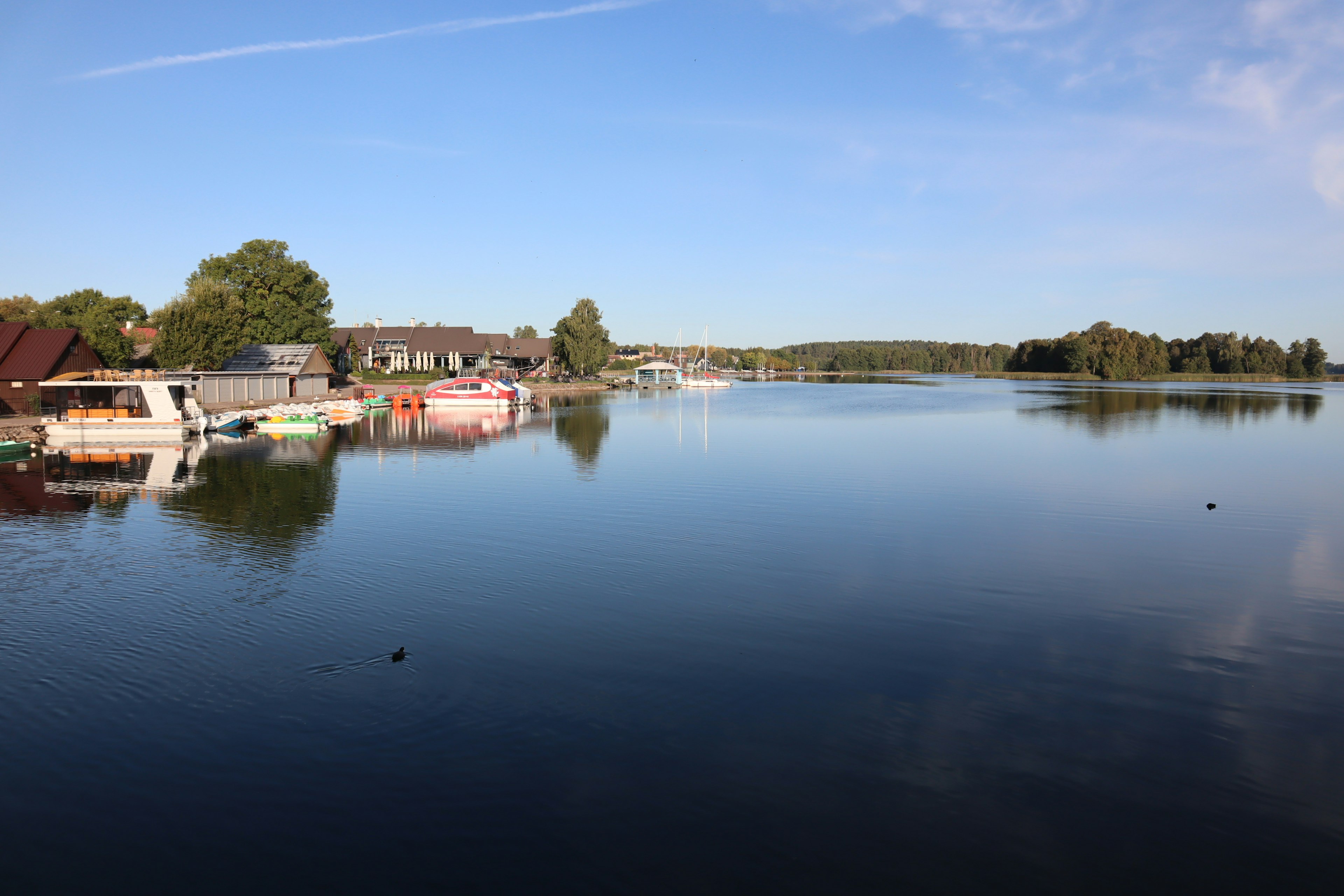 Vista tranquila del lago con botes a lo largo de la orilla