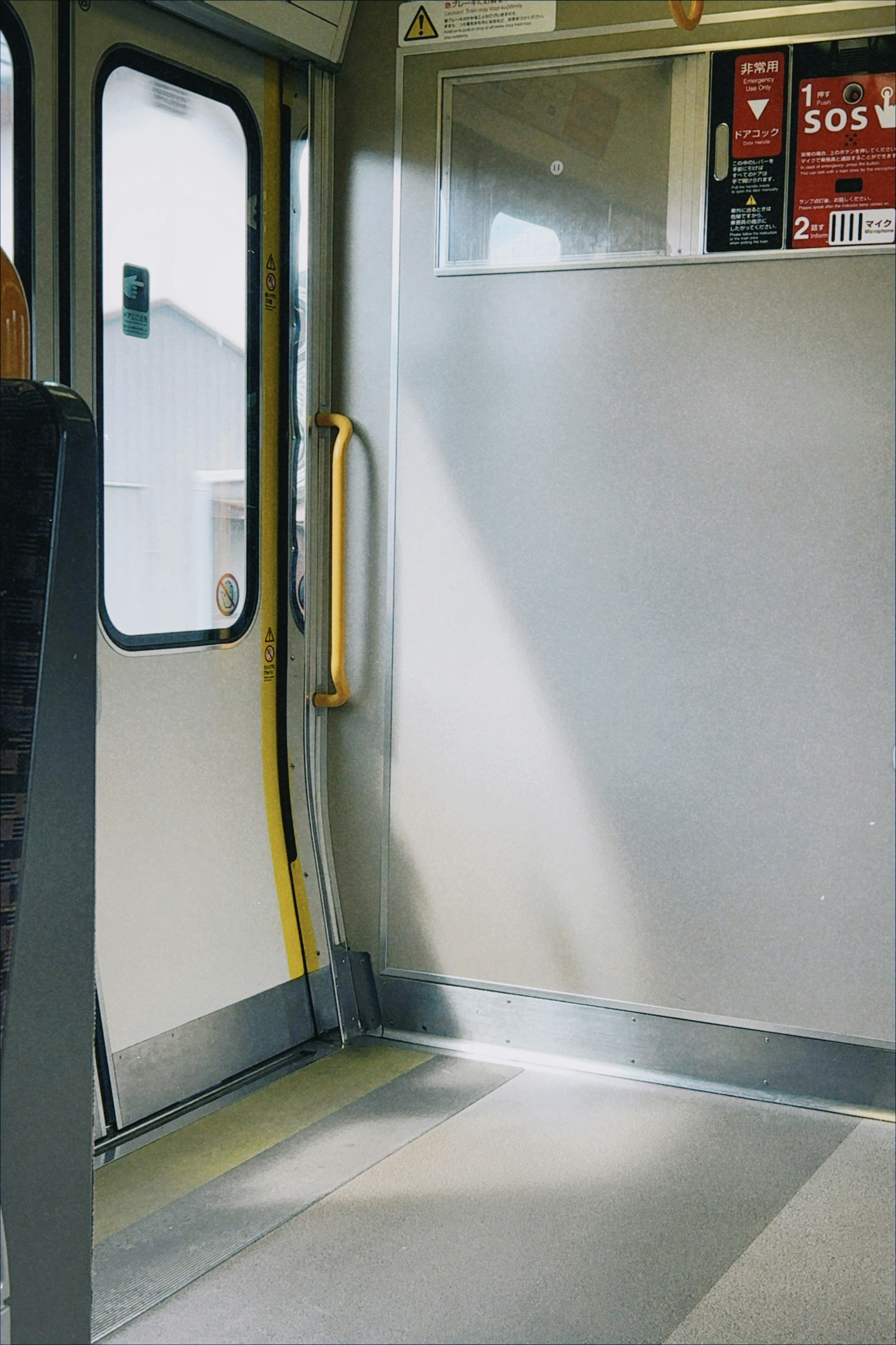 Vista interna di un vagone del treno con porta e corrimano