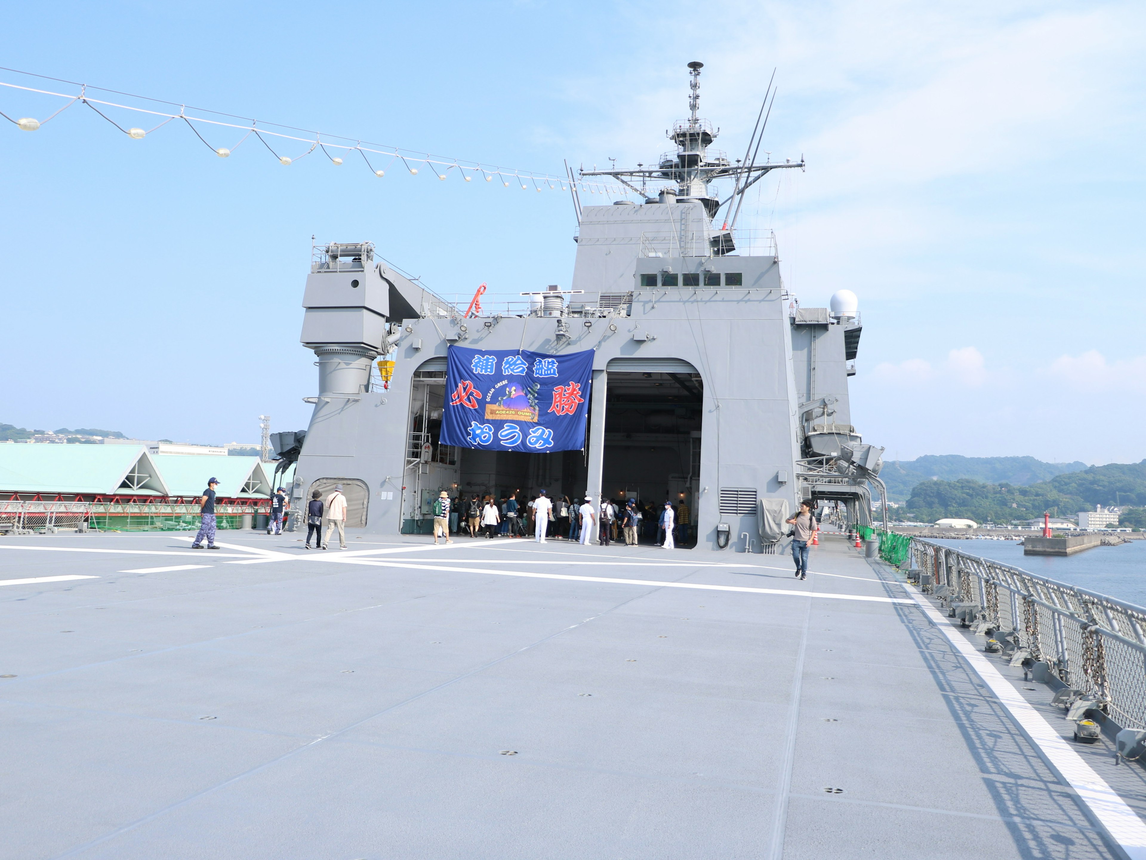 A naval ship deck with people and a banner