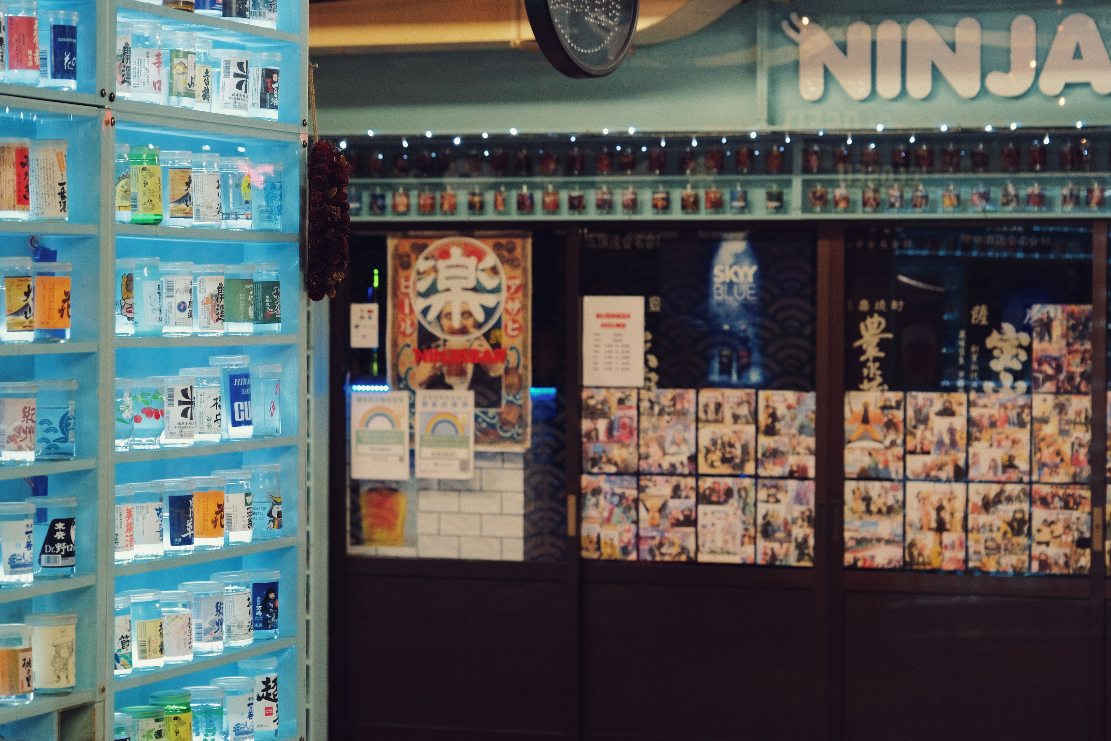 Image d'un extérieur de magasin sur le thème des ninjas avec des étagères de produits illuminées en bleu et des affiches