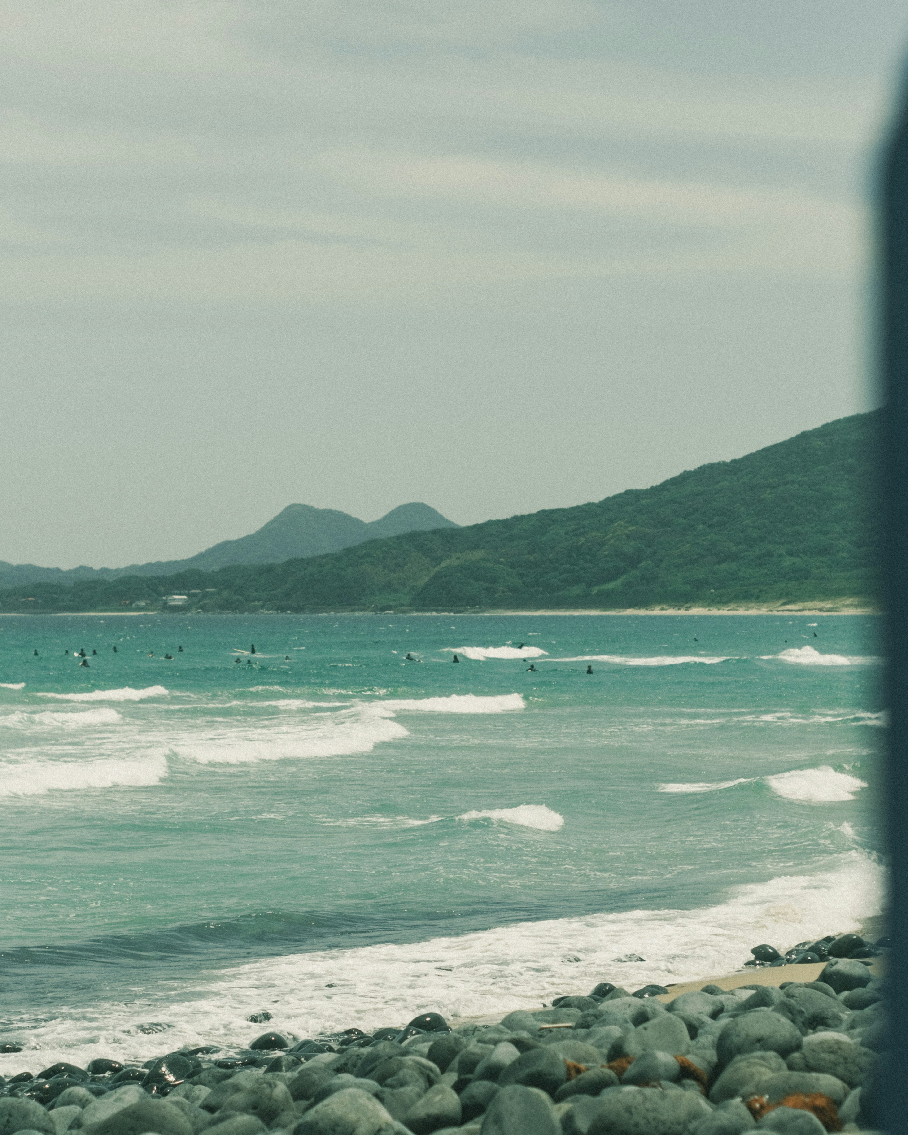 平靜的海洋和波浪，遠處有山脈