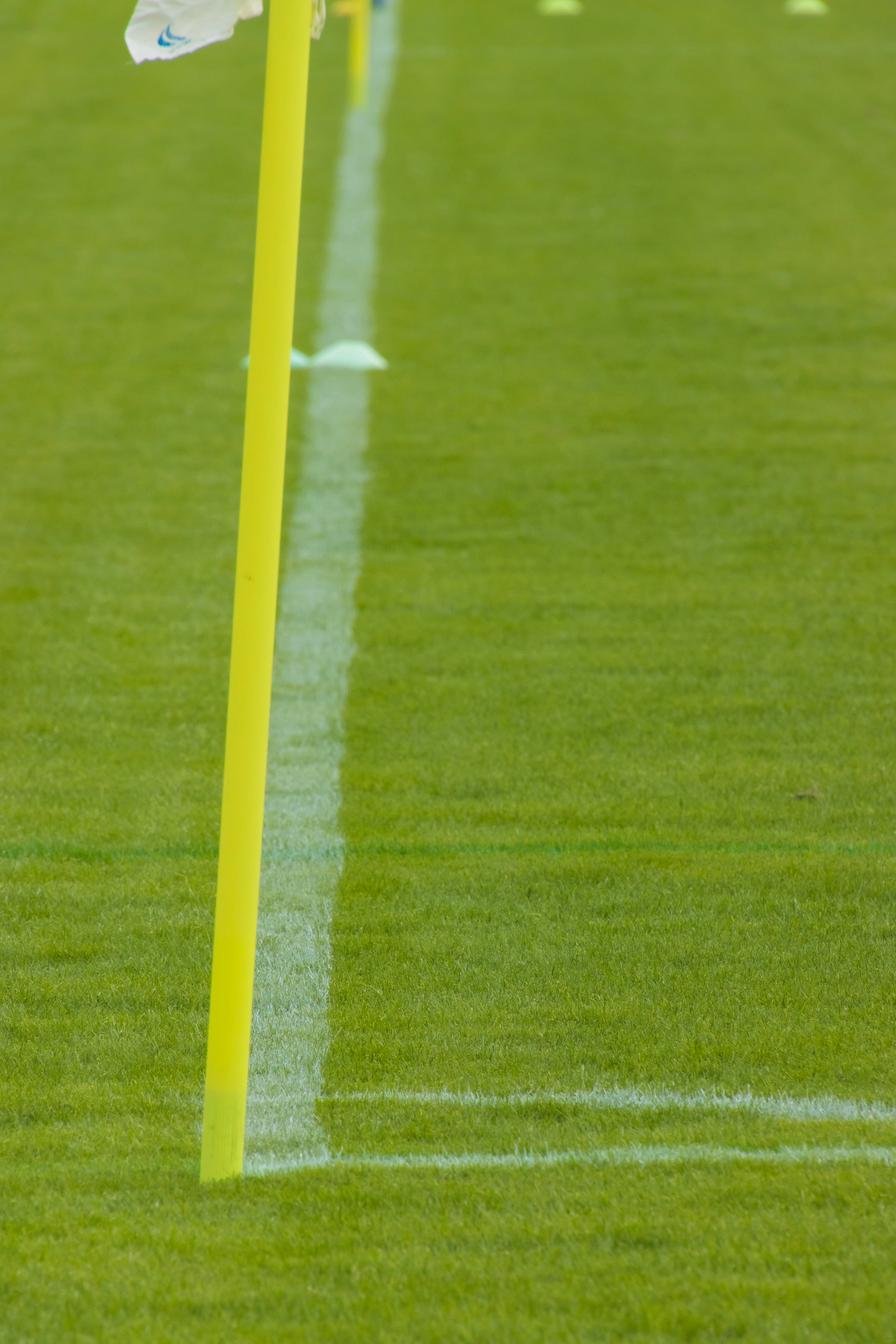 Bright green grass with a yellow corner flag and a white line