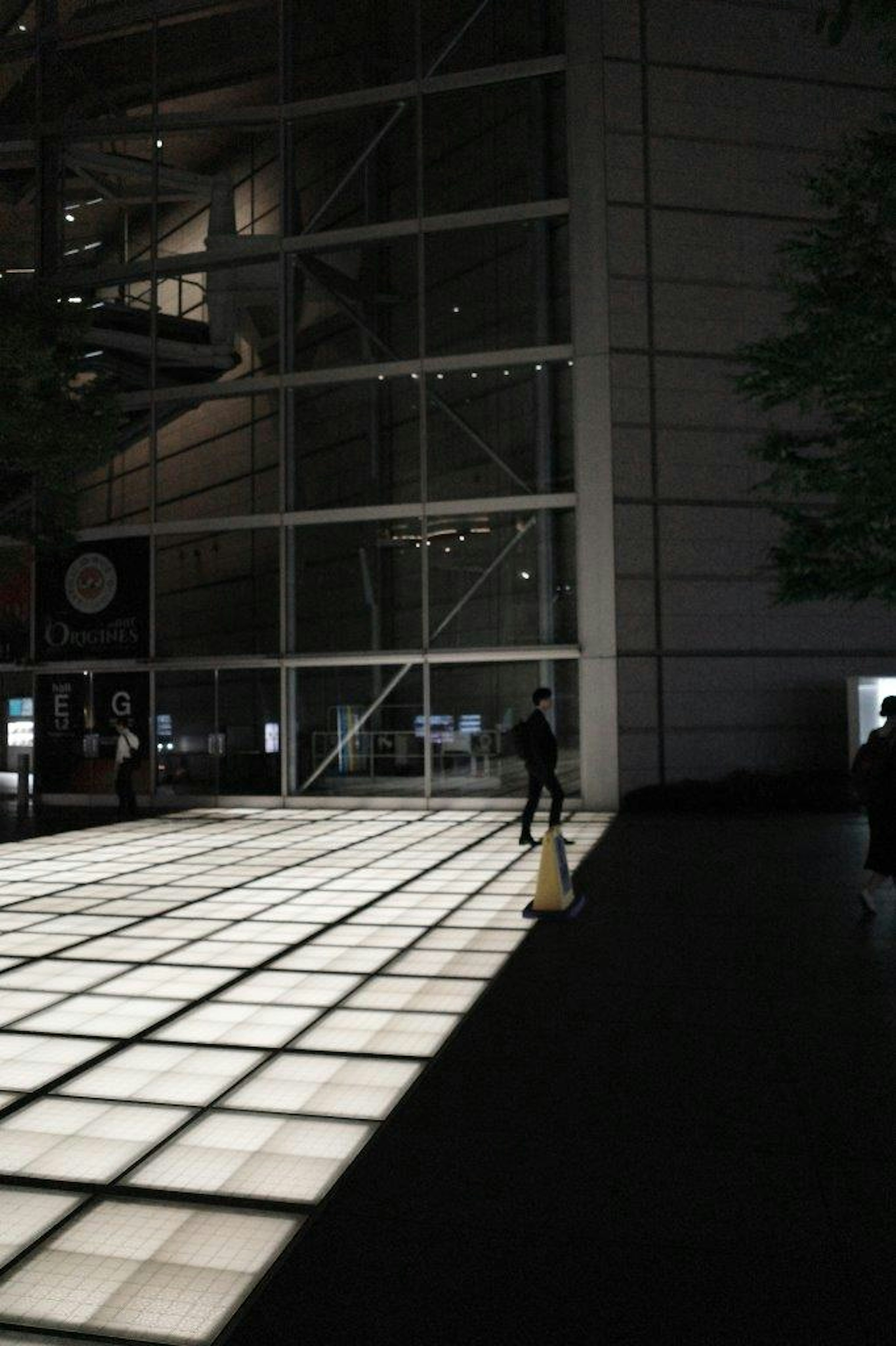 Bright tiled floor in a night urban setting with a silhouette of a person