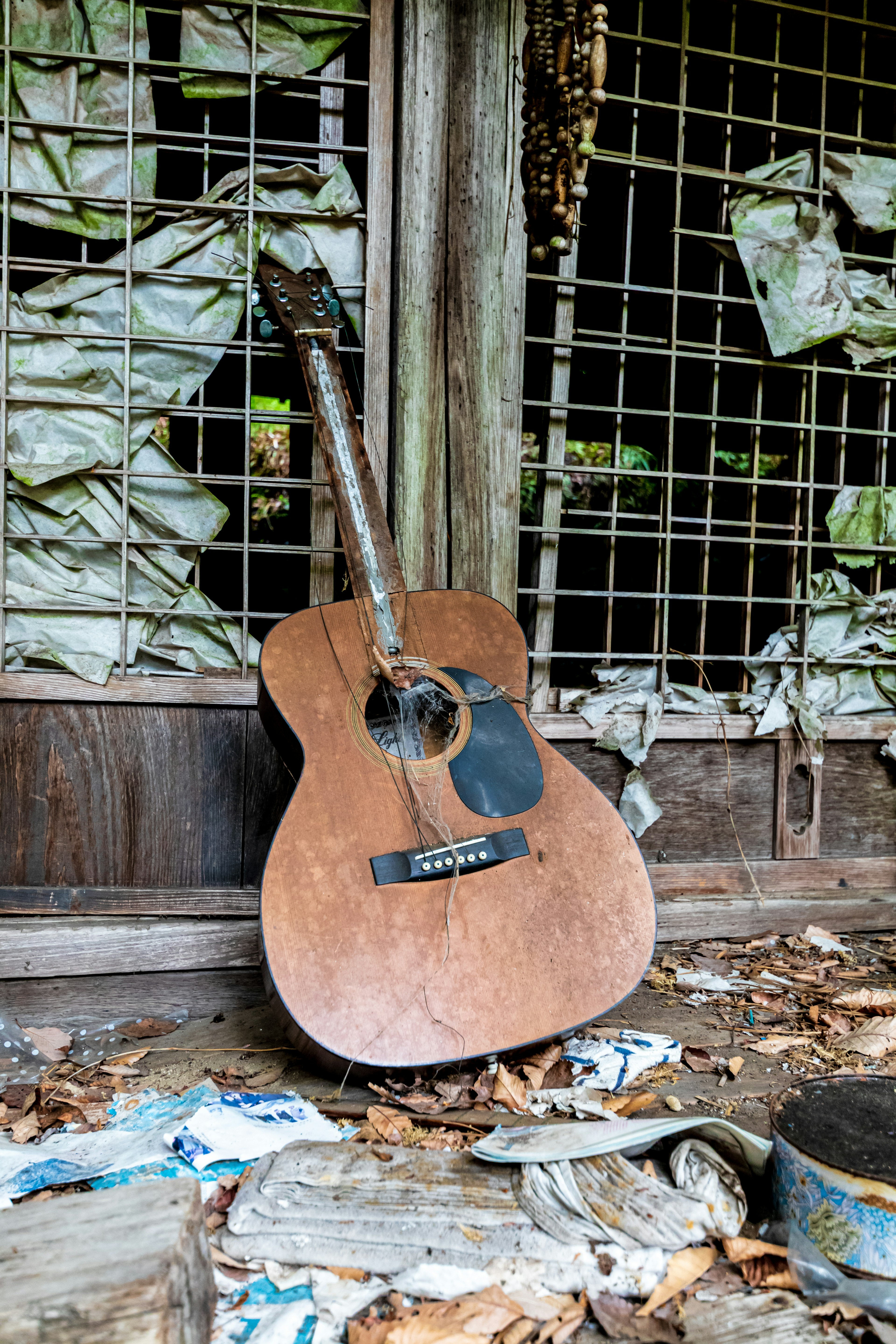 A weathered acoustic guitar resting in an abandoned space