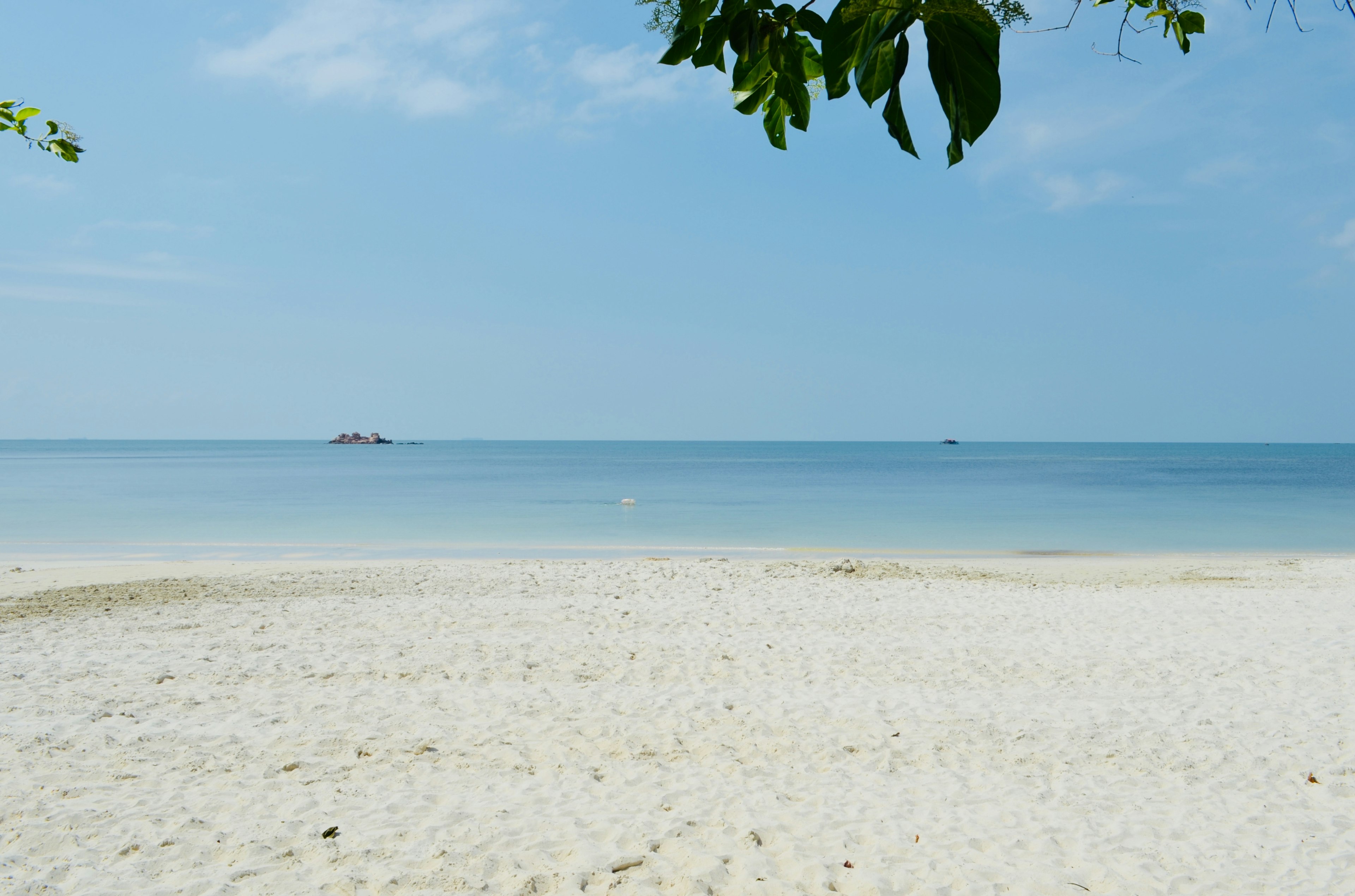 ทิวทัศน์ของชายหาดทรายขาวและมหาสมุทรสีน้ำเงินที่สงบ