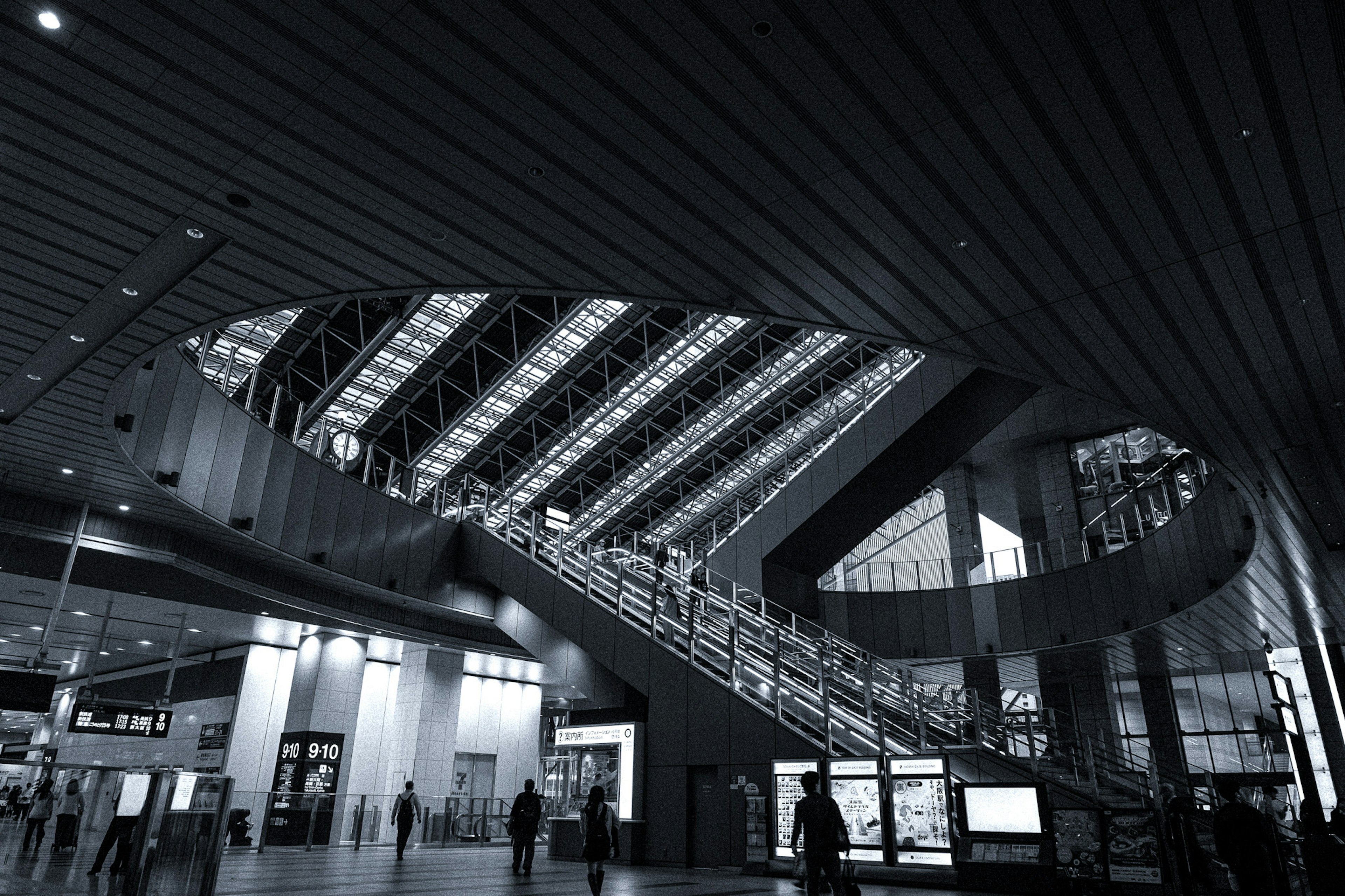 Interior de un edificio moderno con una gran escalera y un techo de vidrio