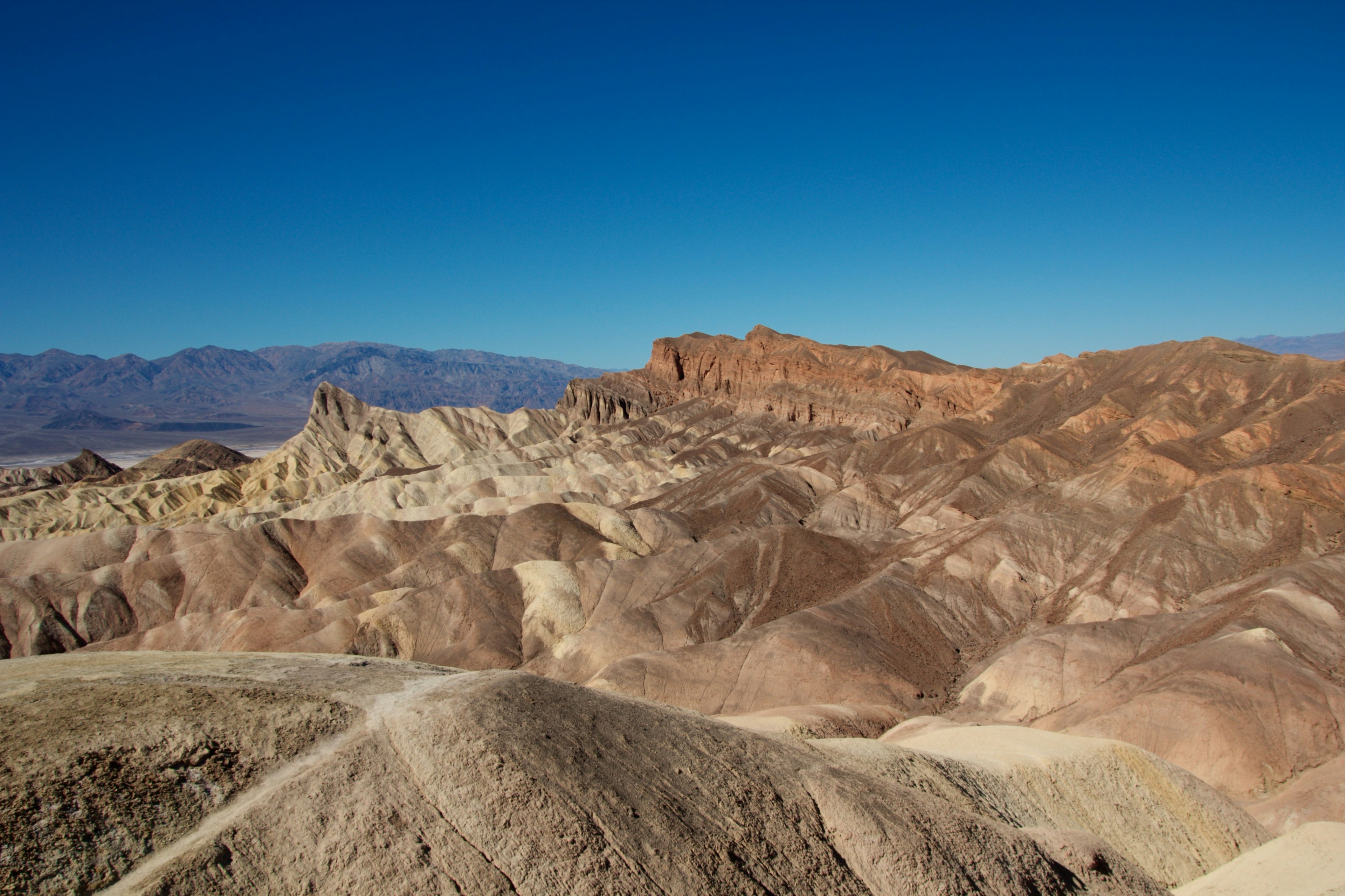 Vista escénica de montañas en capas coloridas bajo un cielo azul claro