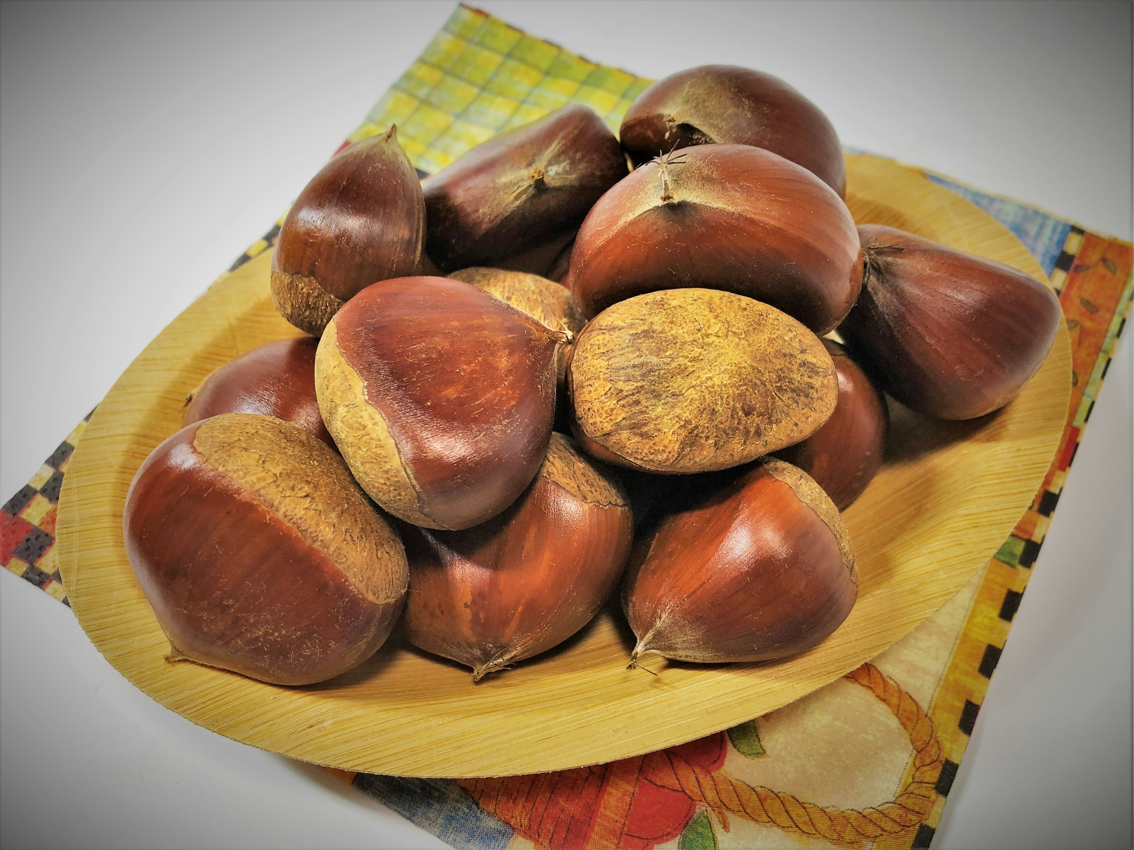 A cluster of chestnuts on a wooden plate