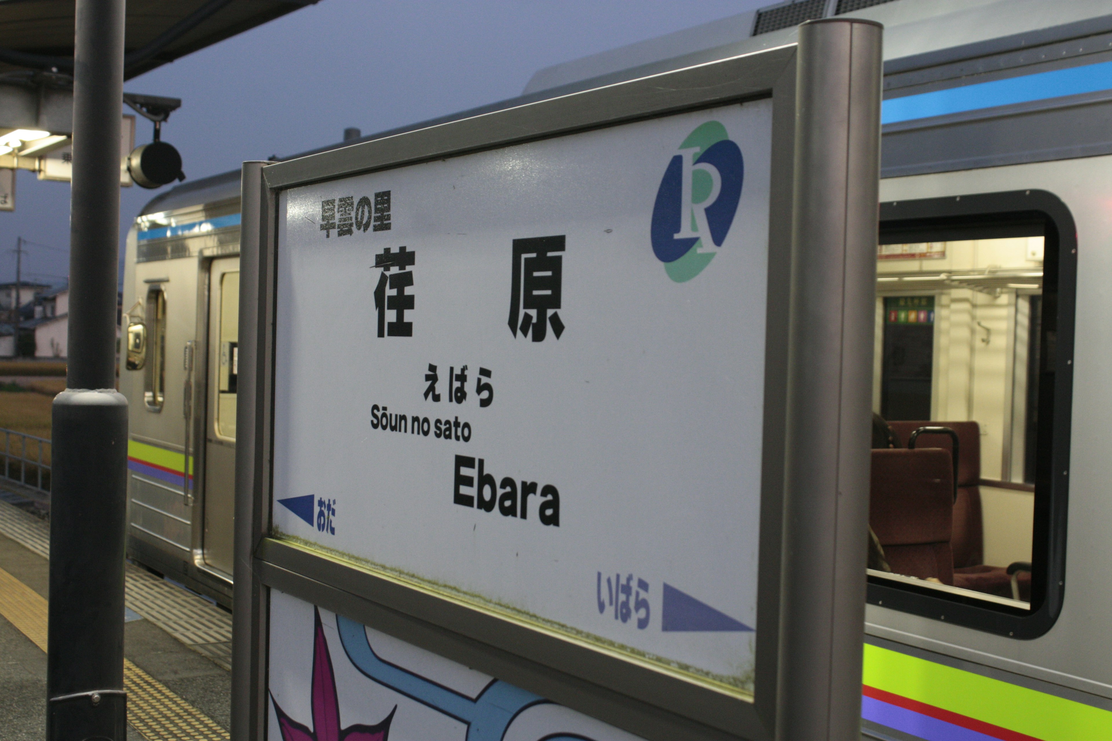 Sign for Ebara Station with a train partially visible