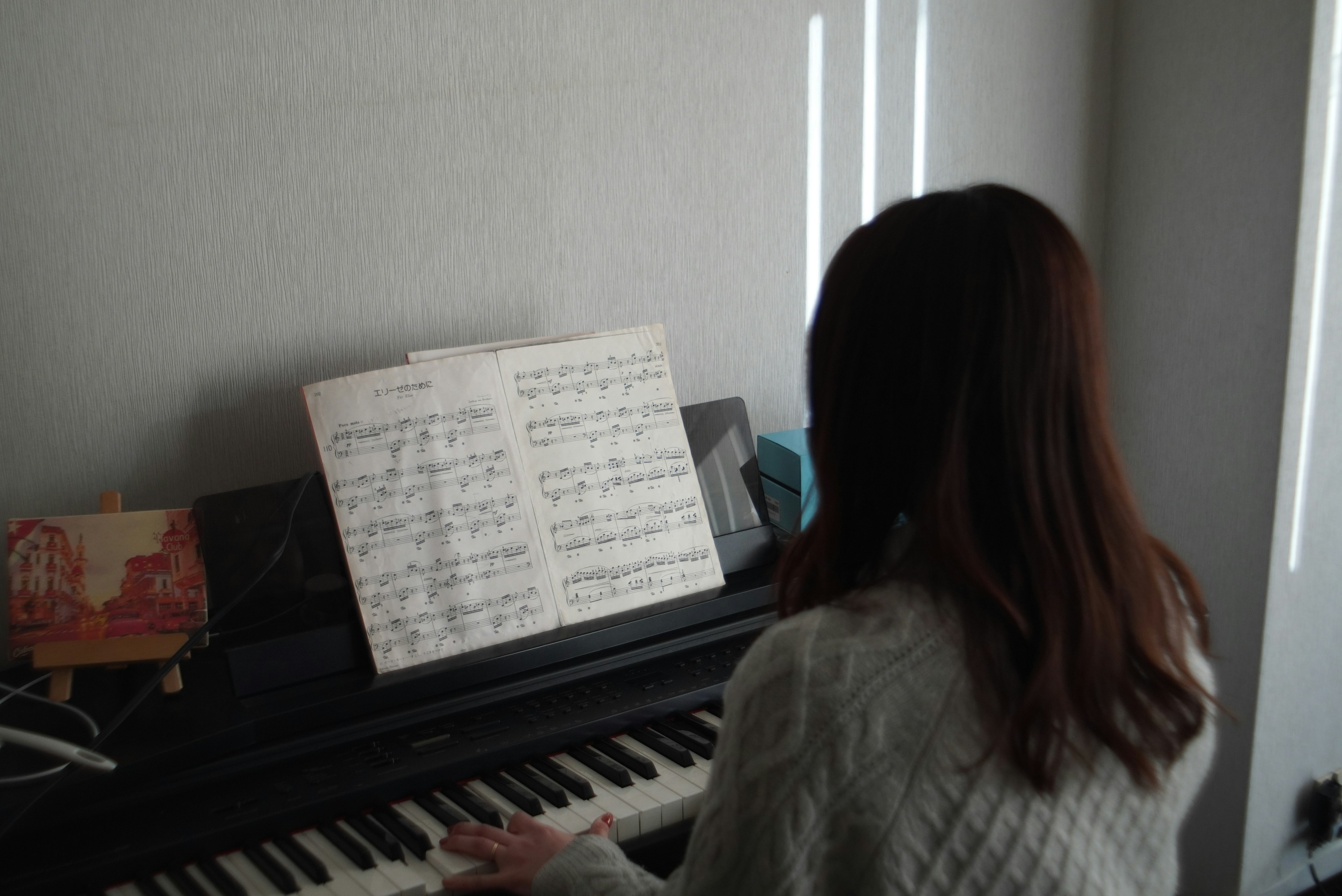 Femme jouant du piano avec des partitions visibles