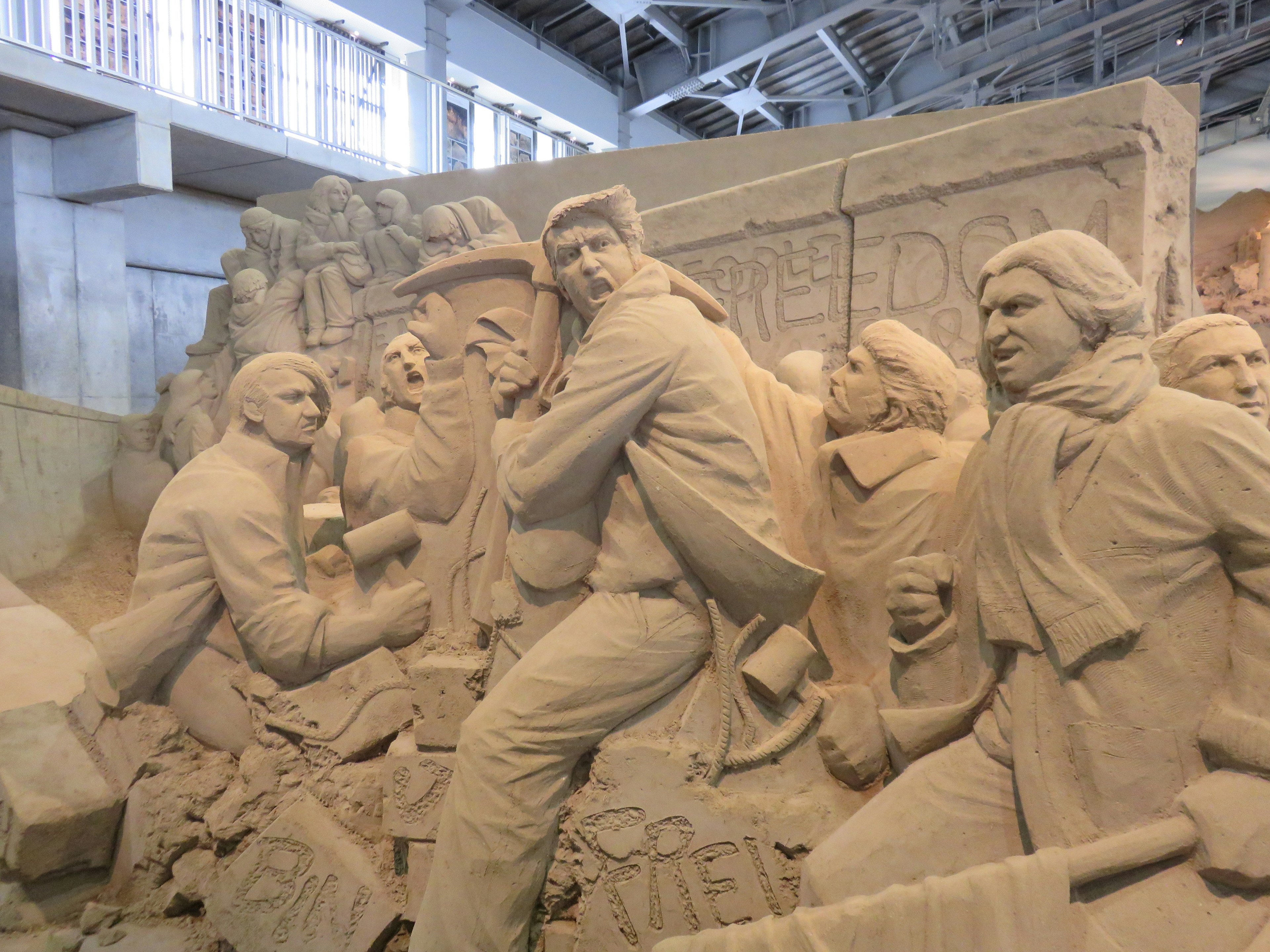 Sand sculpture depicting historical figures in dynamic poses