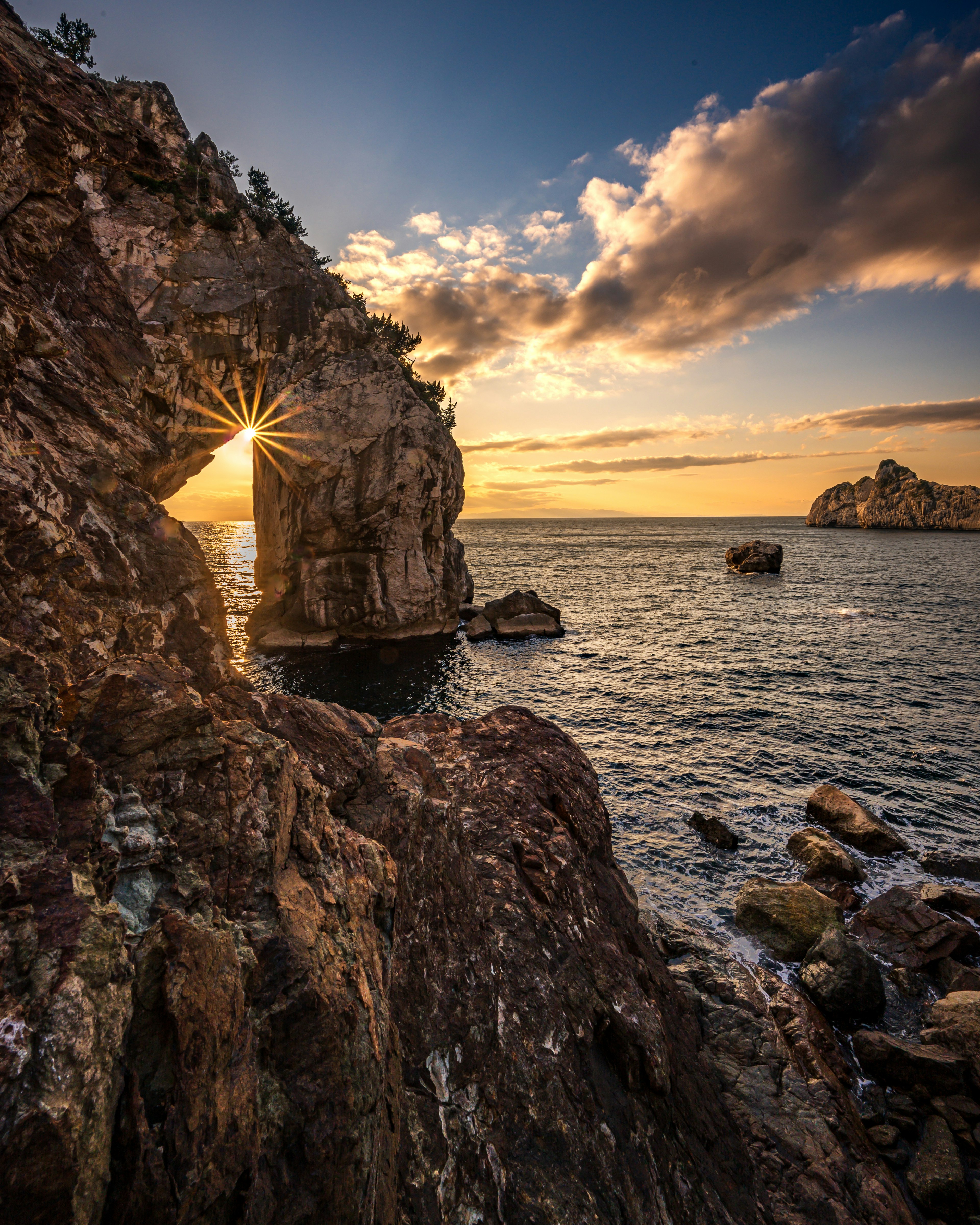 Magnifique paysage maritime avec une arche rocheuse et un coucher de soleil éclatant