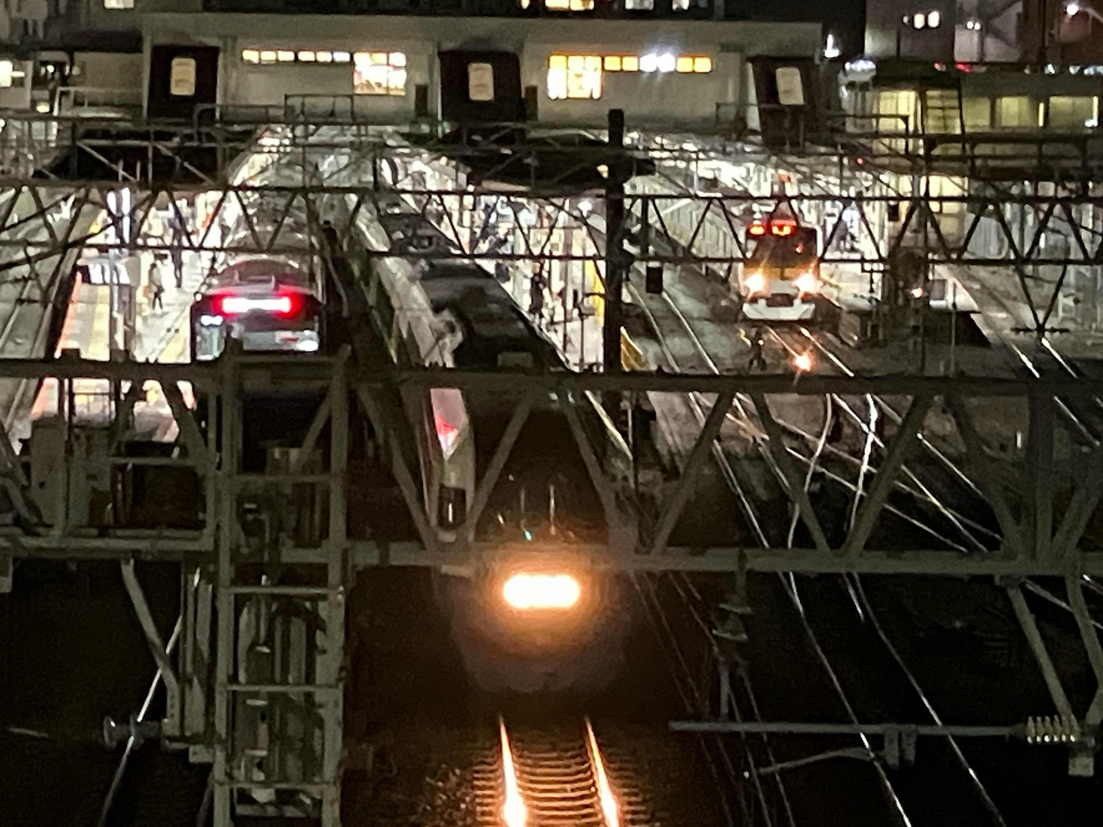 夜の鉄道駅に停車中の列車と複数の線路の風景