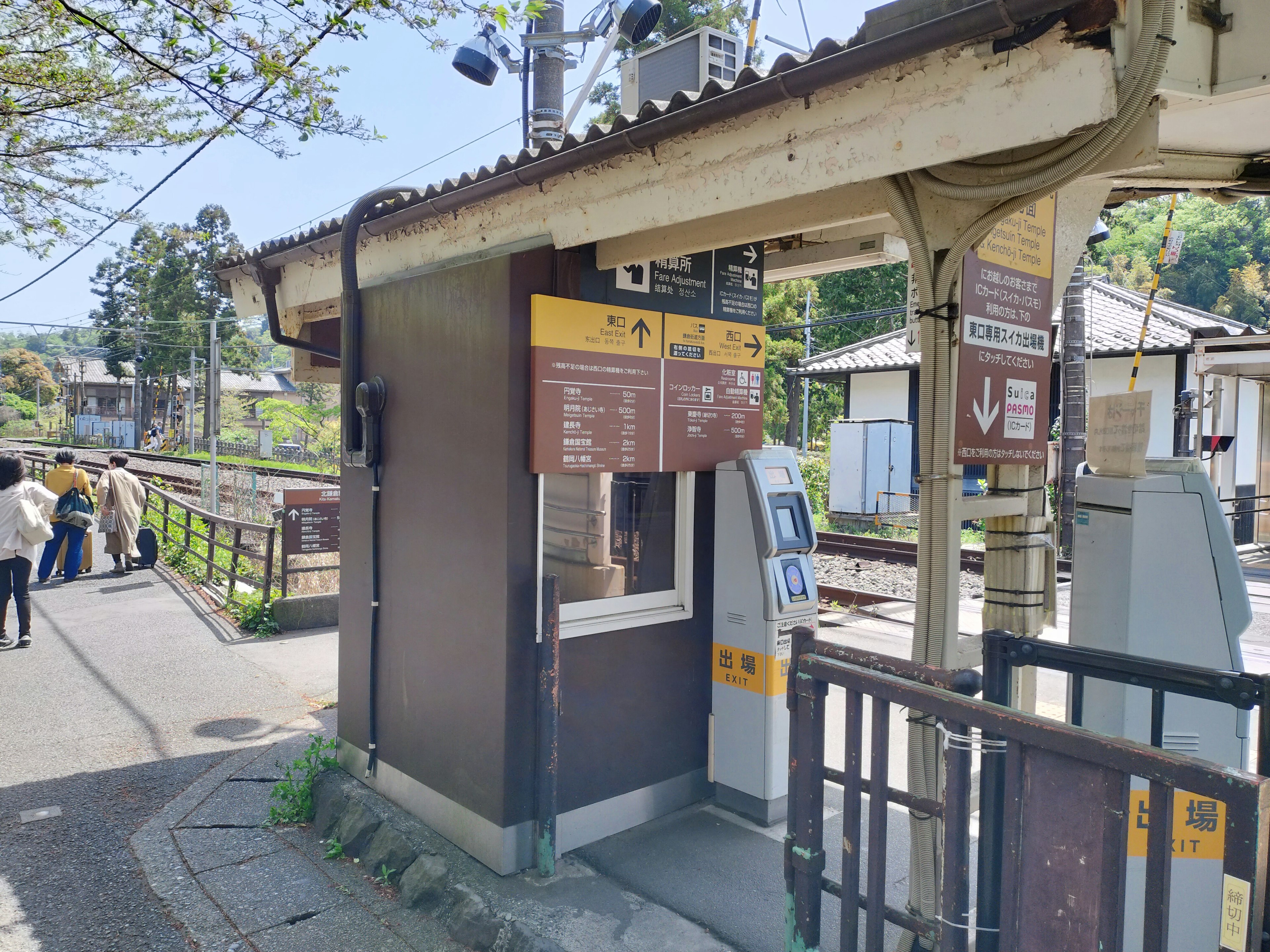 Botteghino della stazione con segnali e pedoni vicini