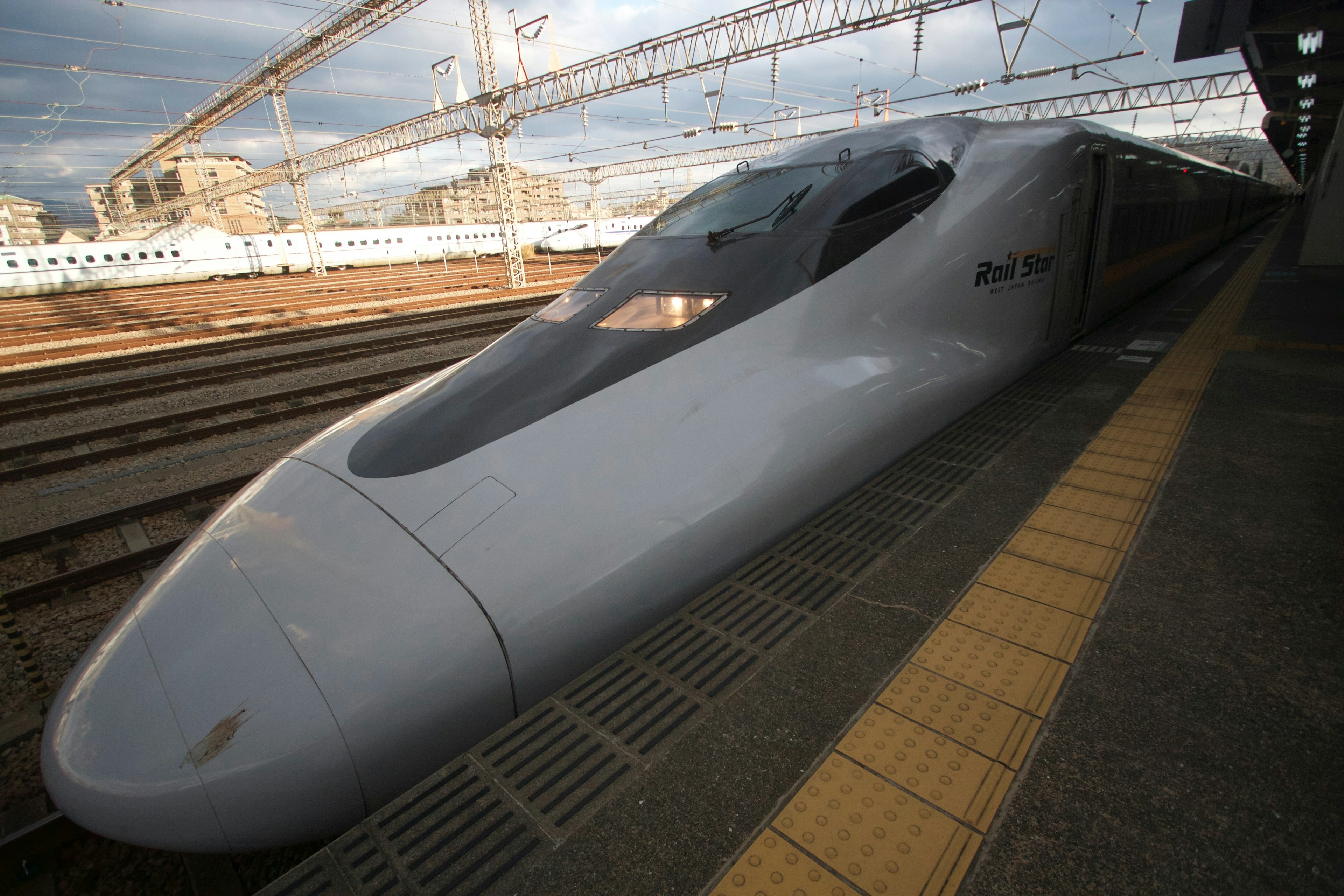 新幹線の先端部が駅のプラットフォームに停車中