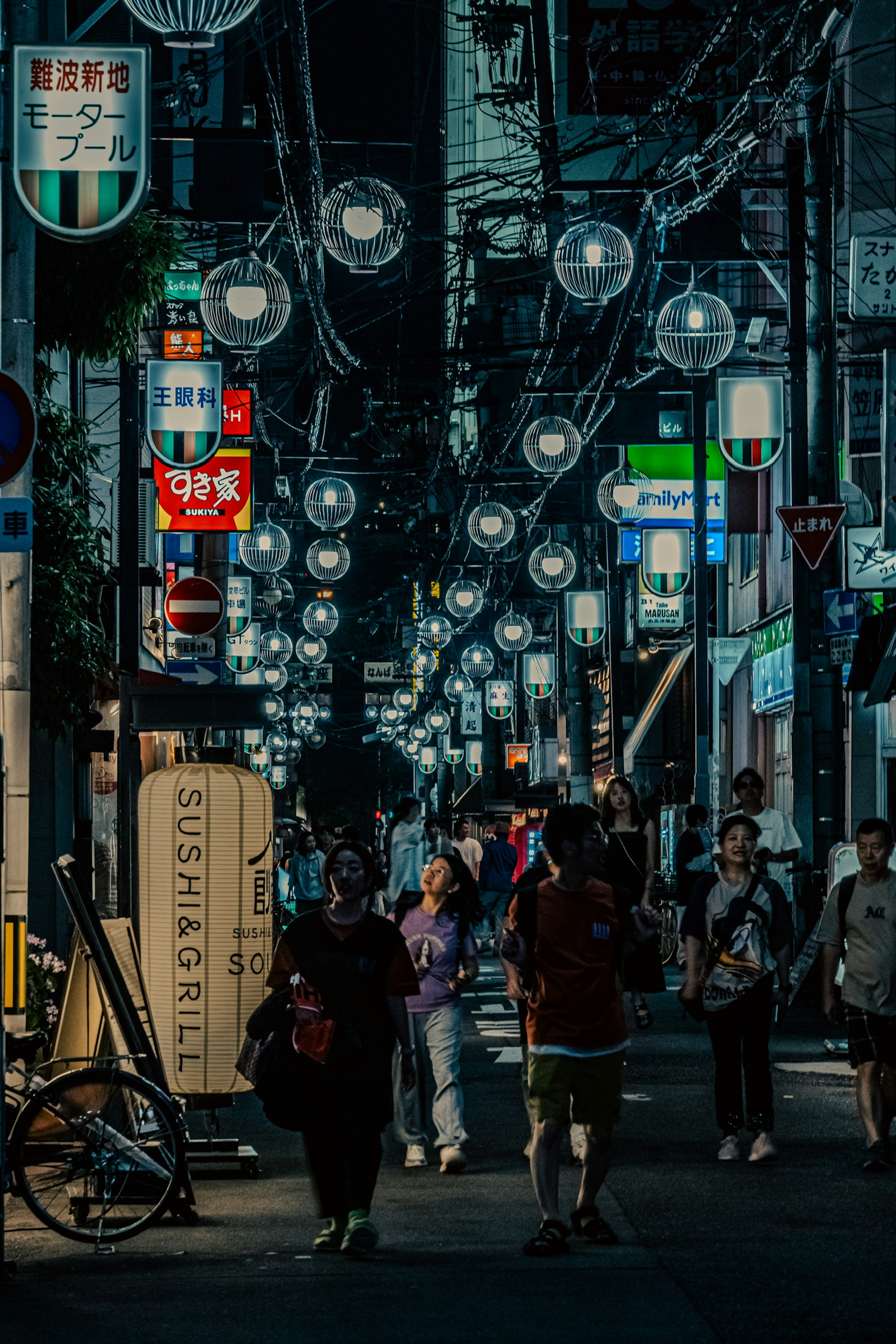 Calle iluminada con faroles y personas caminando