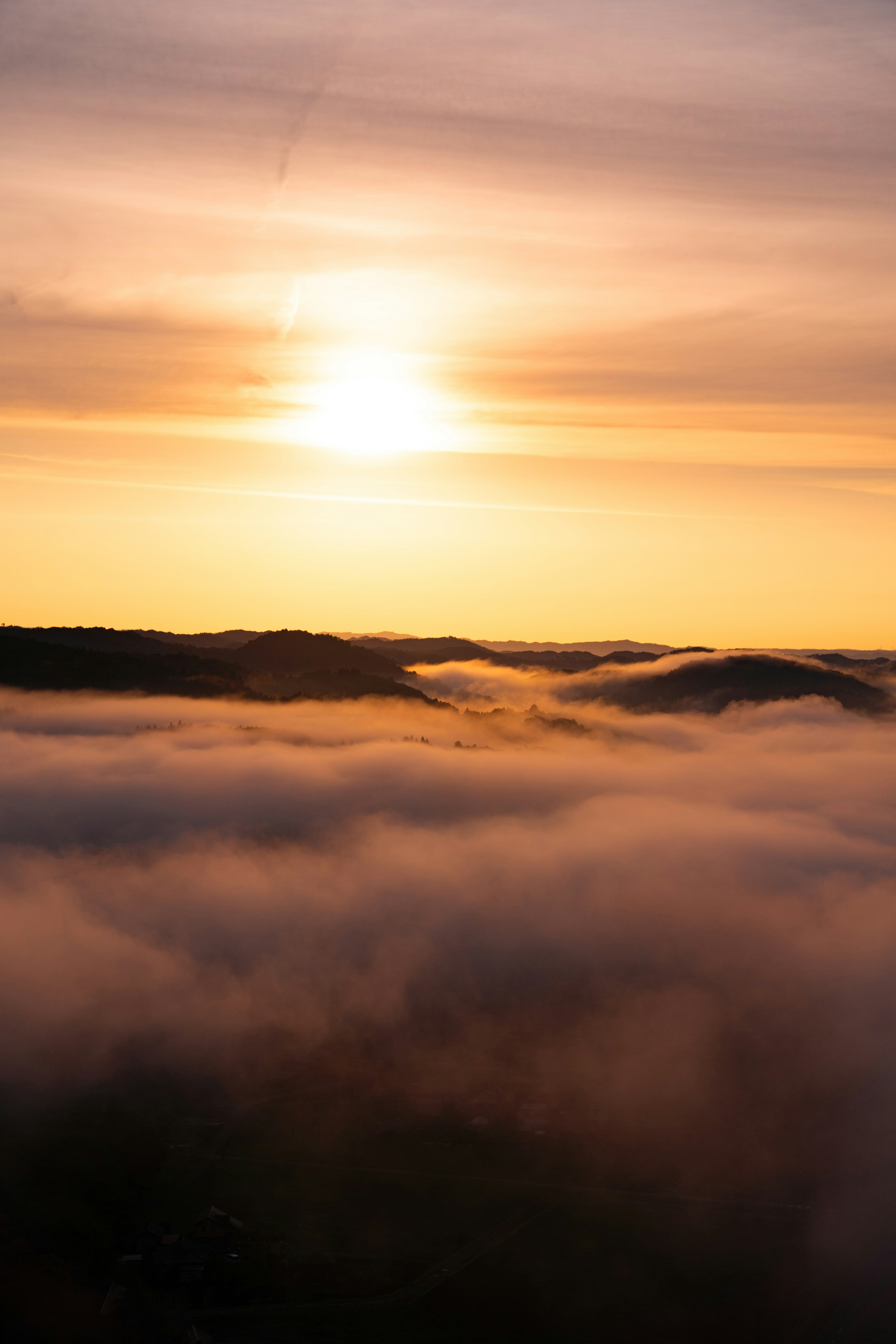 A scenic view of the sun rising above the clouds