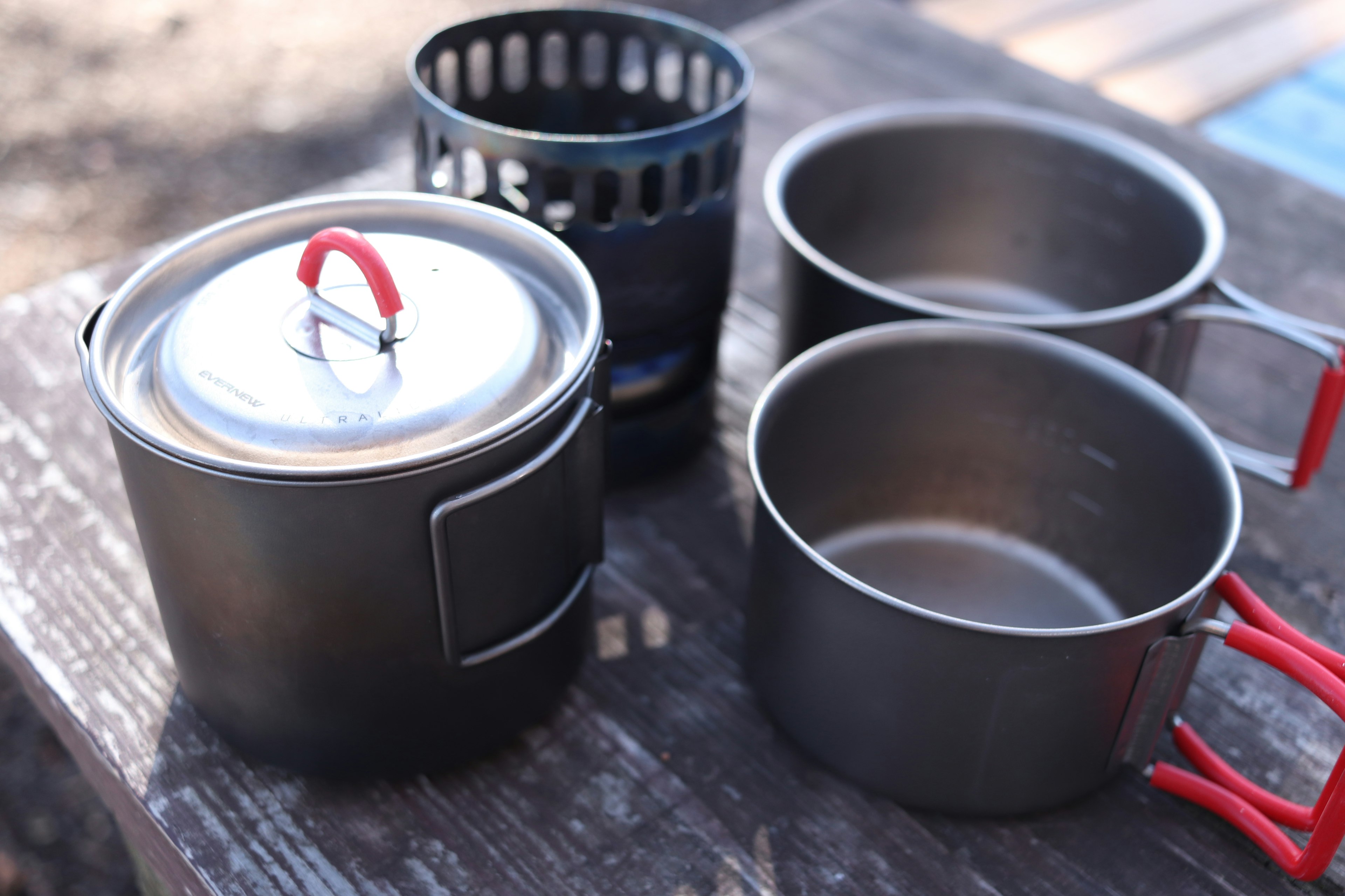 Camping cookware arranged on a wooden table