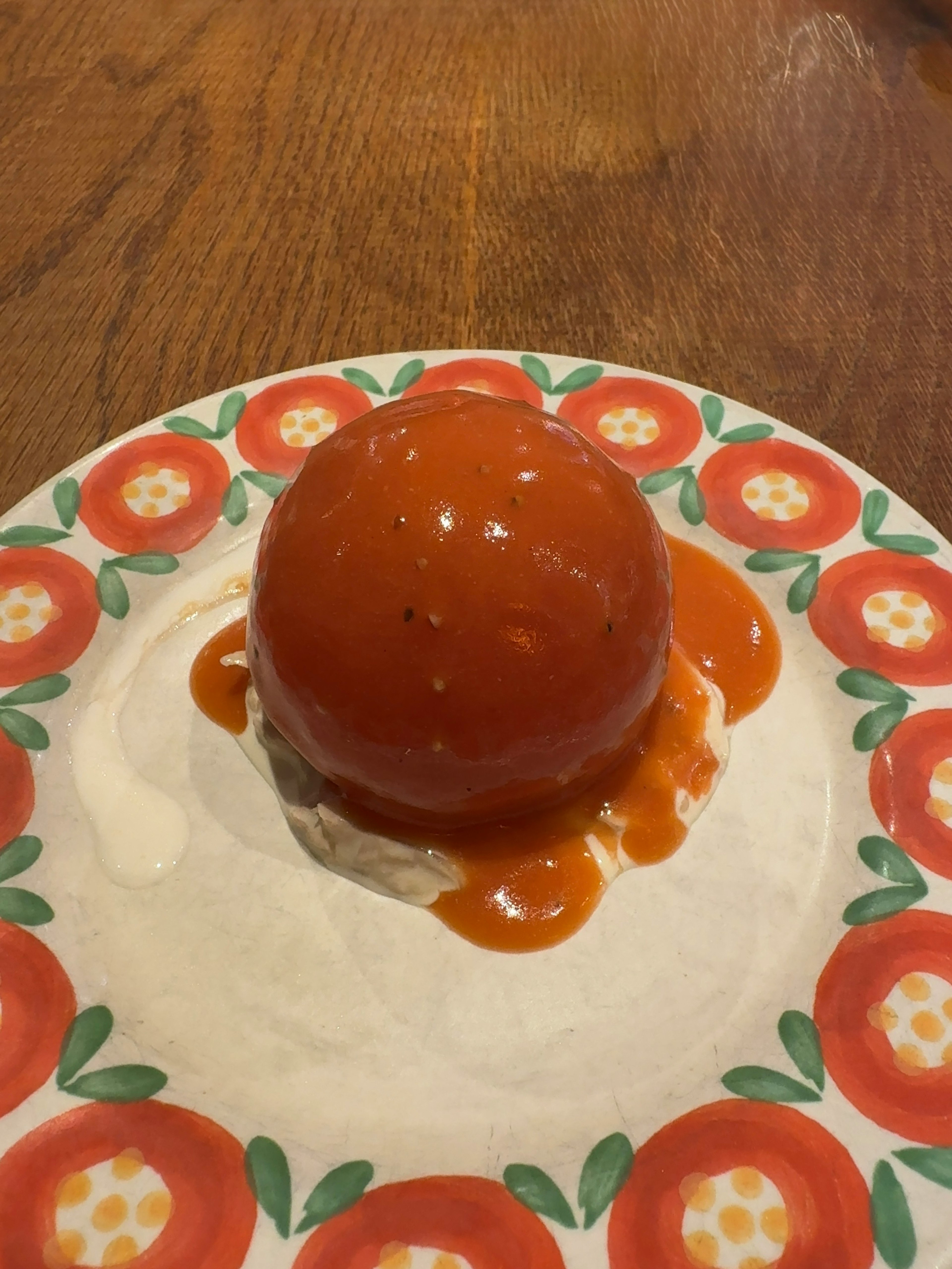 Un dessert en gelée rouge présenté sur une assiette décorative