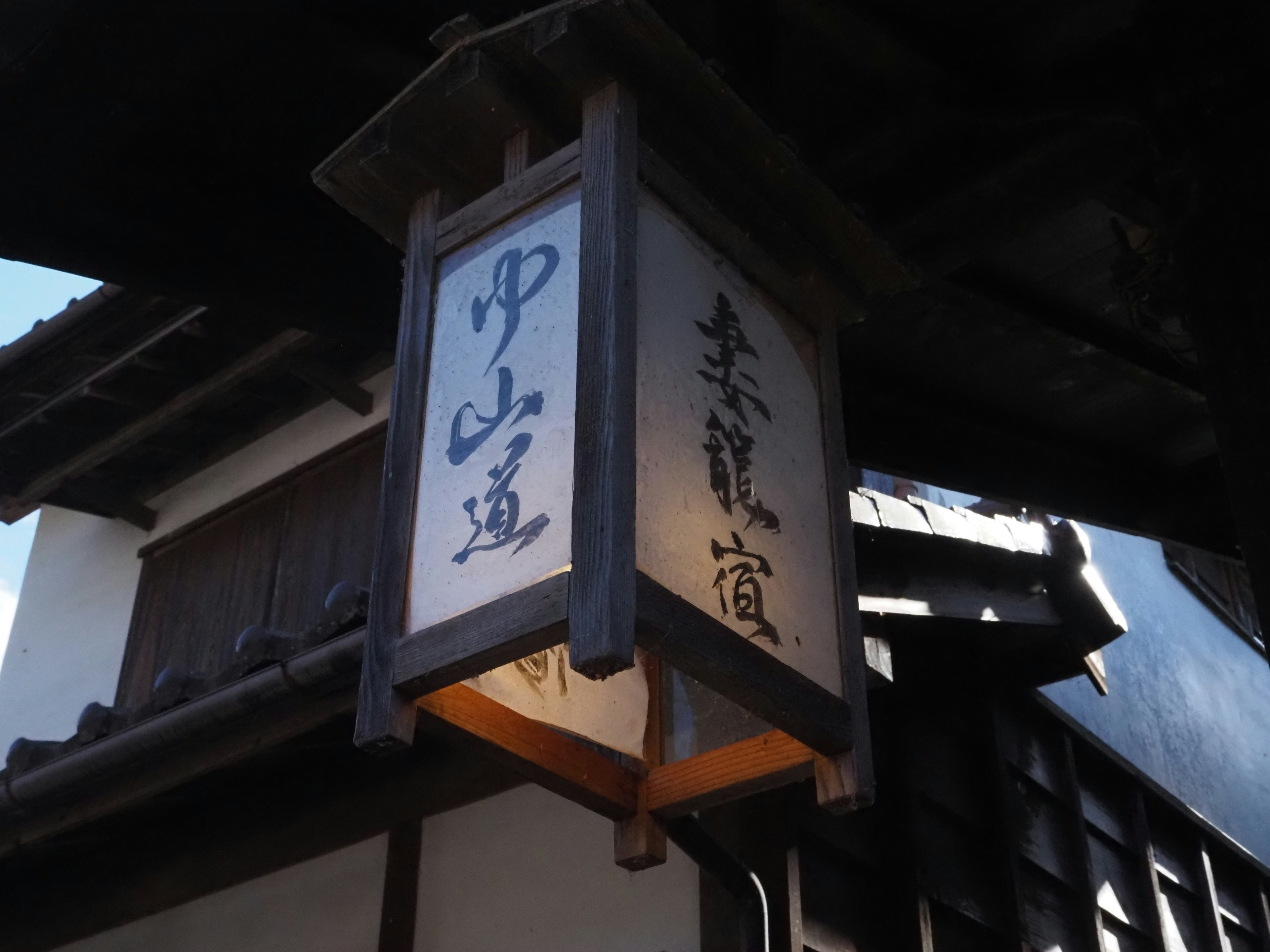 Traditional Japanese street sign with wooden frame and calligraphy