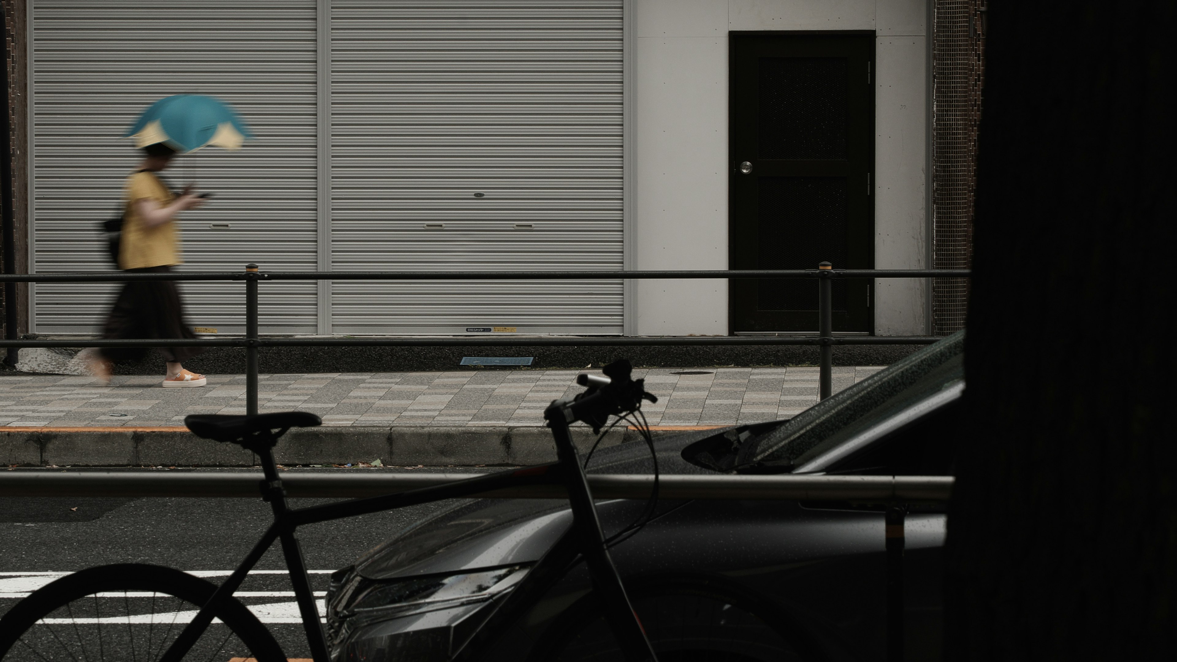 A person walking with an umbrella in an urban setting