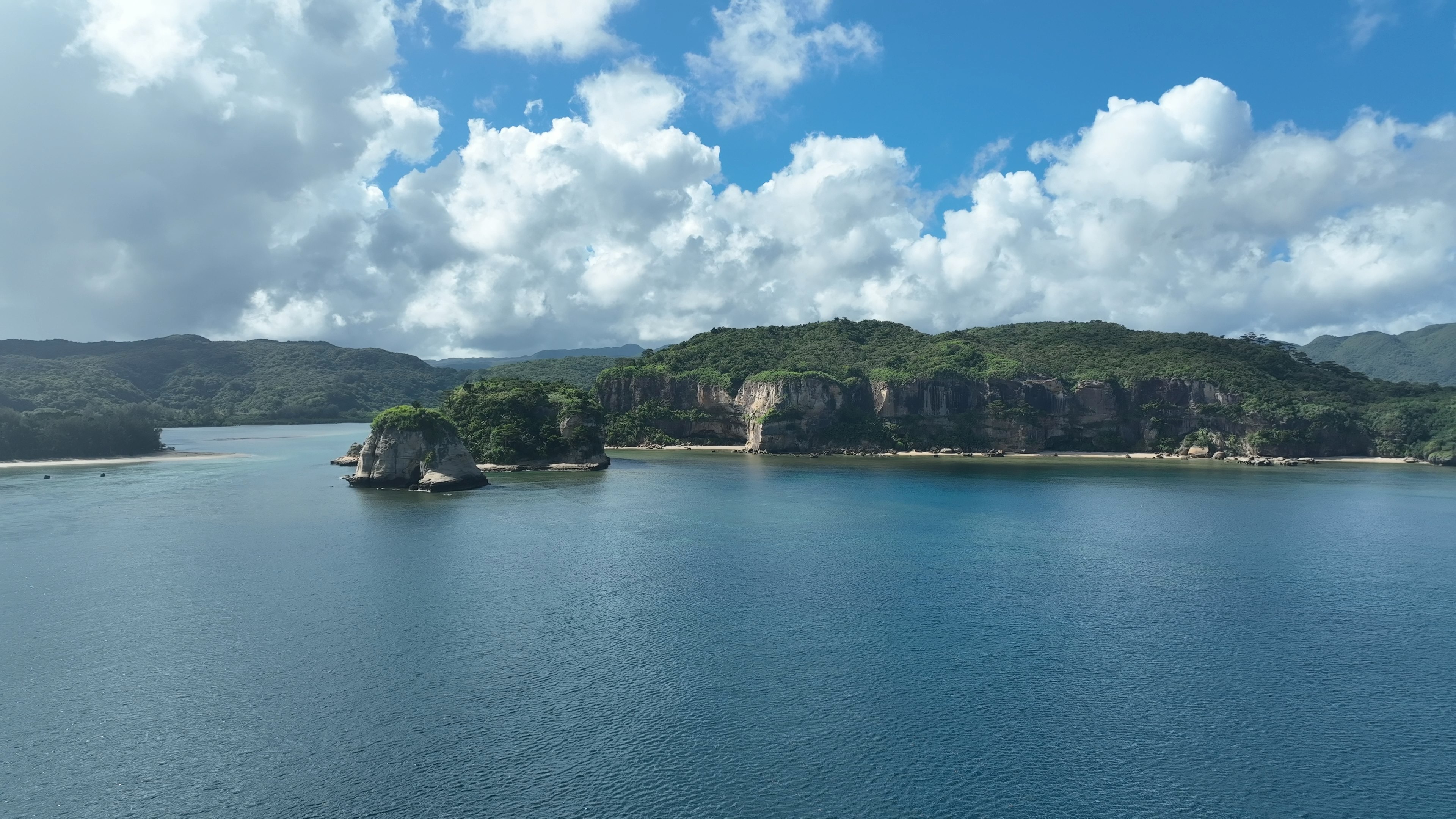 Vista escénica de islas verdes rodeadas de agua azul y nubes