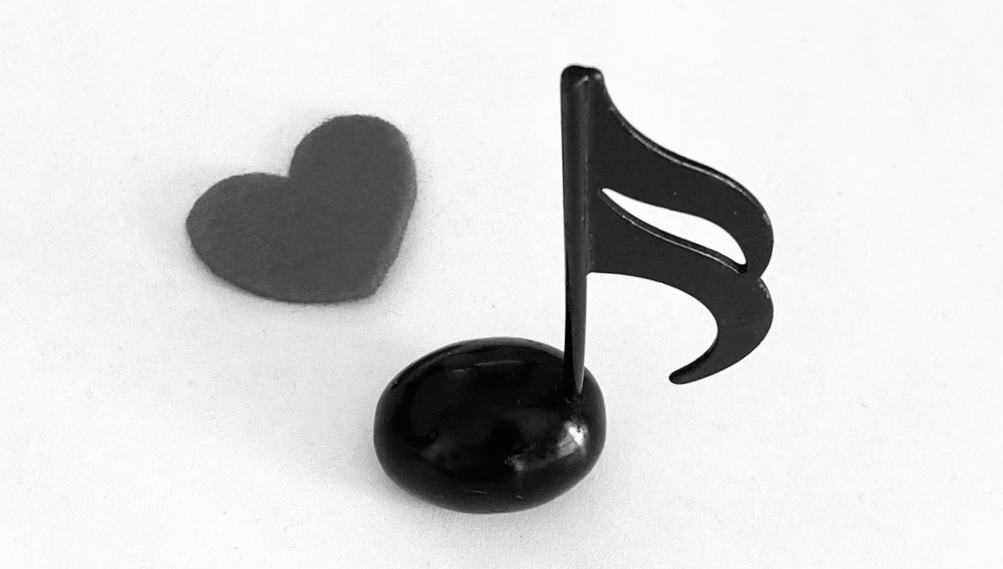 A black musical note and a heart-shaped object are placed together