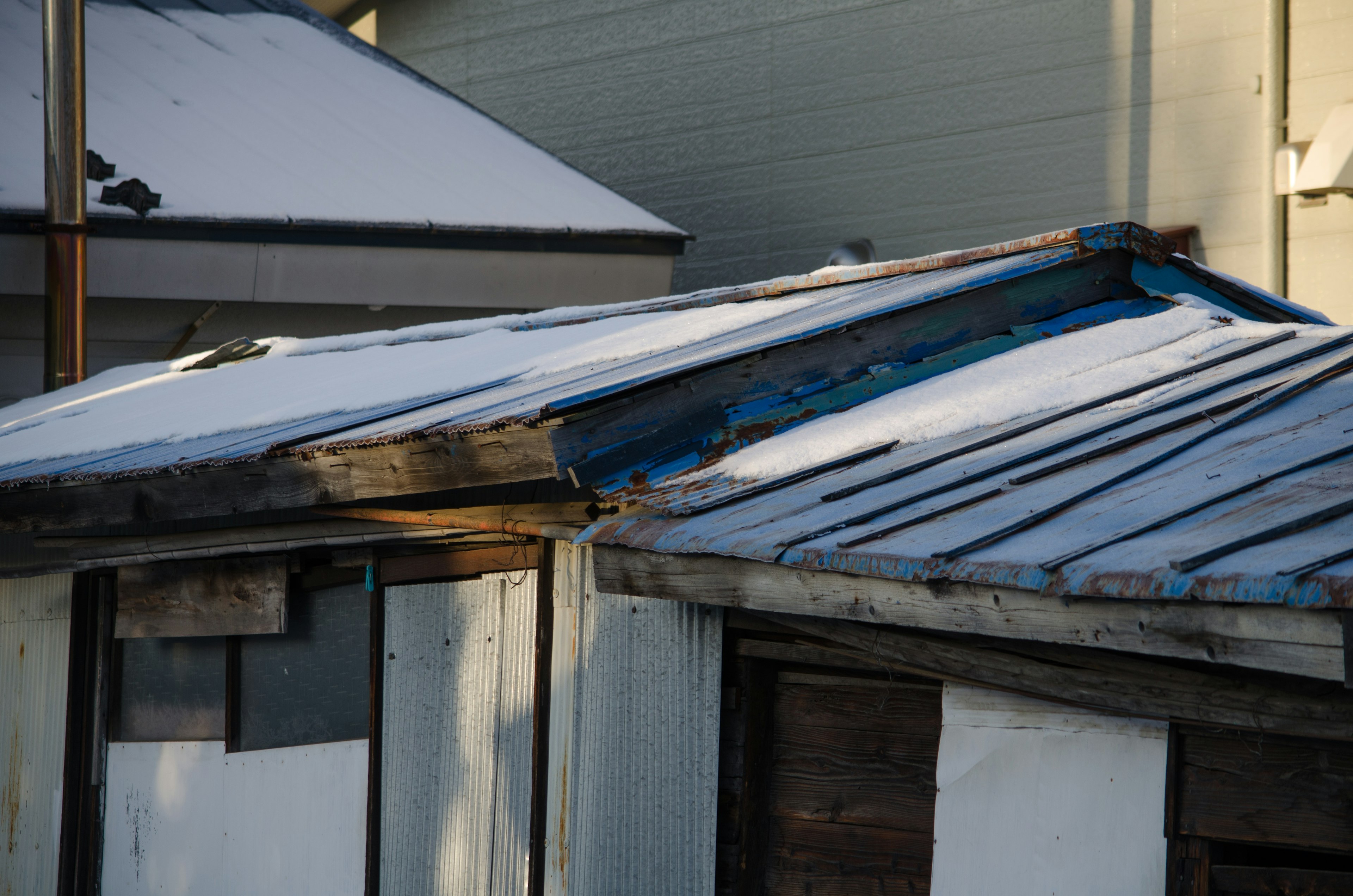 Detailed view of an old shed roof covered in snow