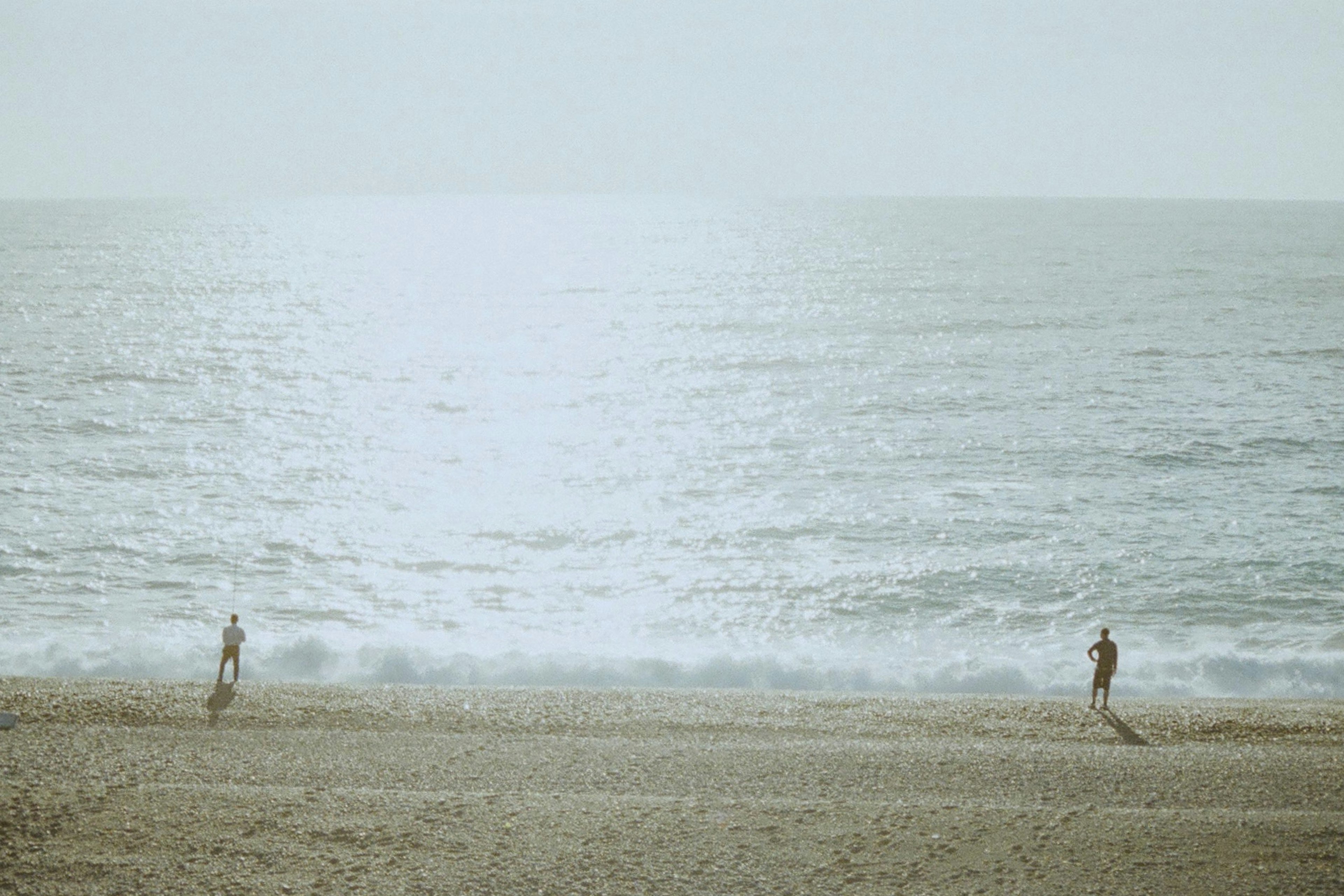 Due figure che corrono sulla spiaggia con onde