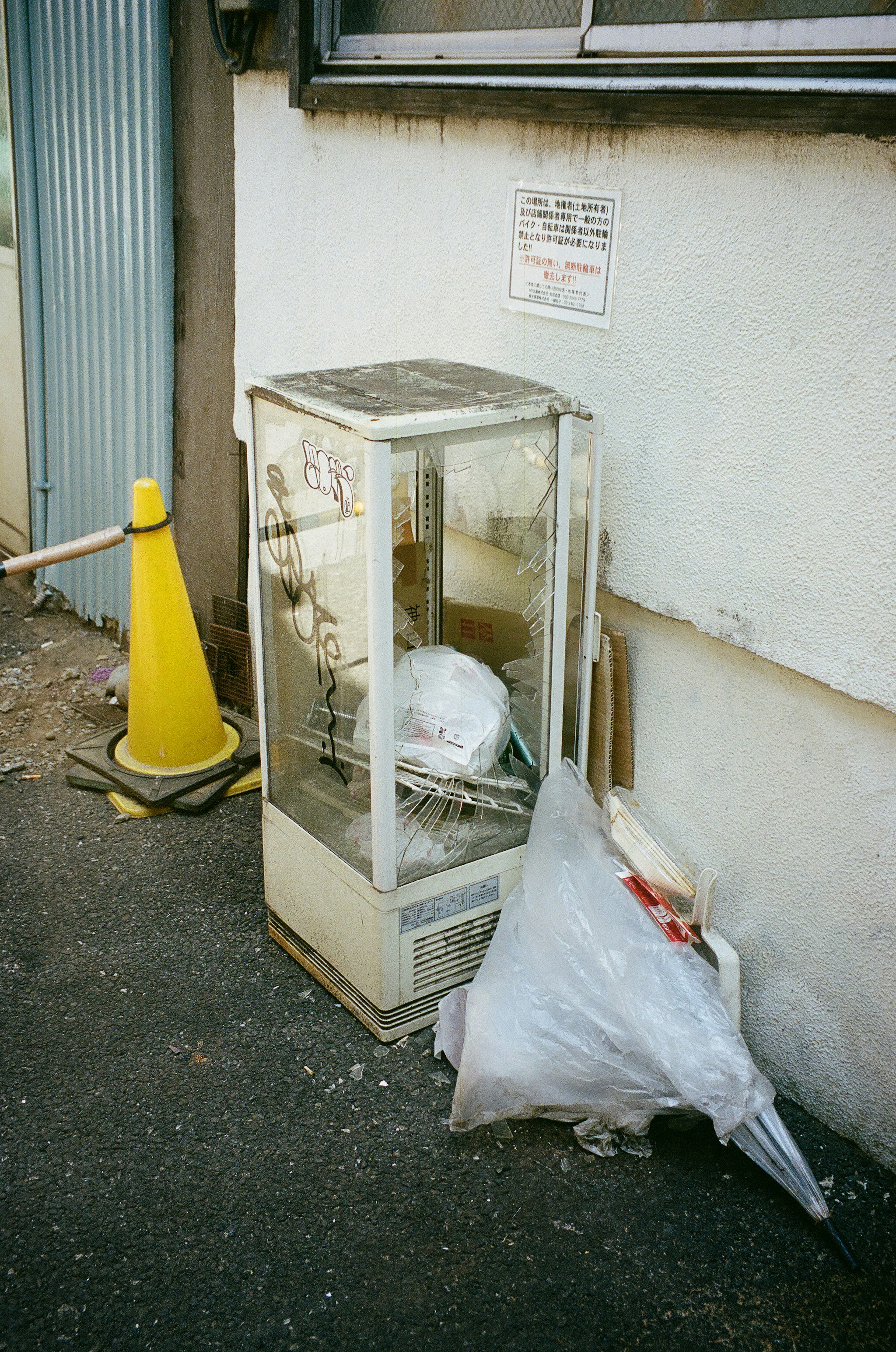 Glass display case next to a wall with a garbage bag