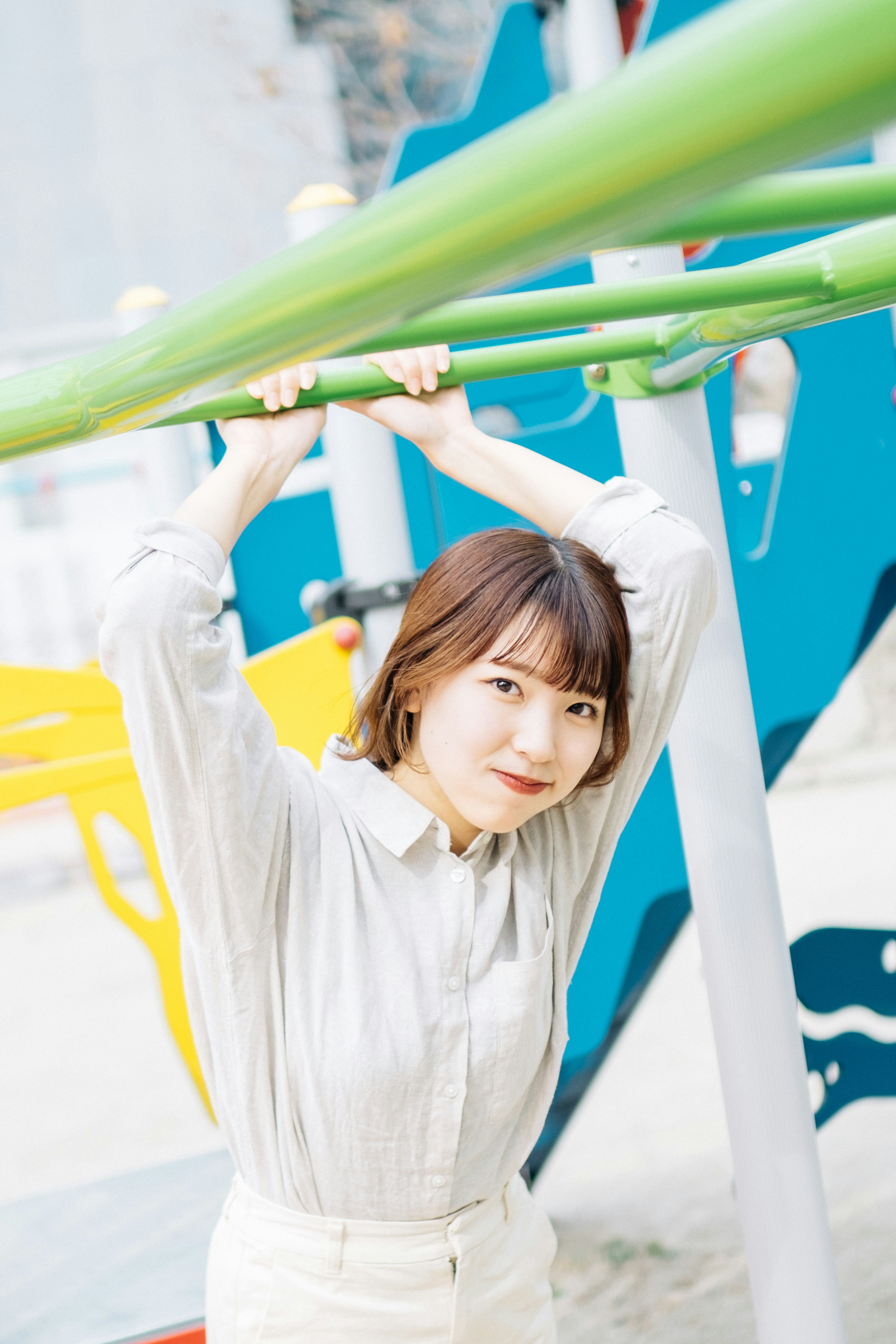 A woman playing on playground equipment in a park