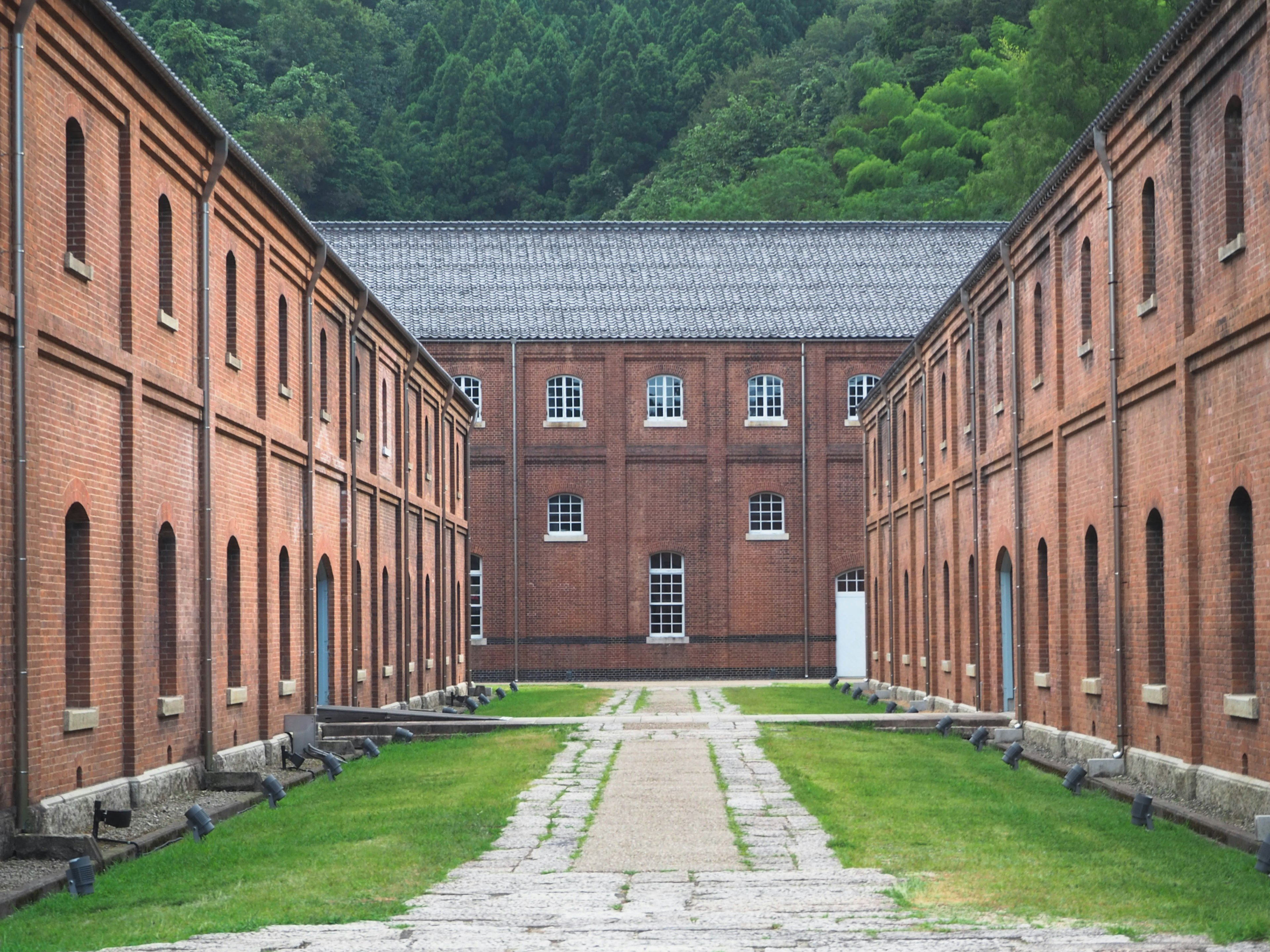 Scenic view of brick buildings lined along a green pathway