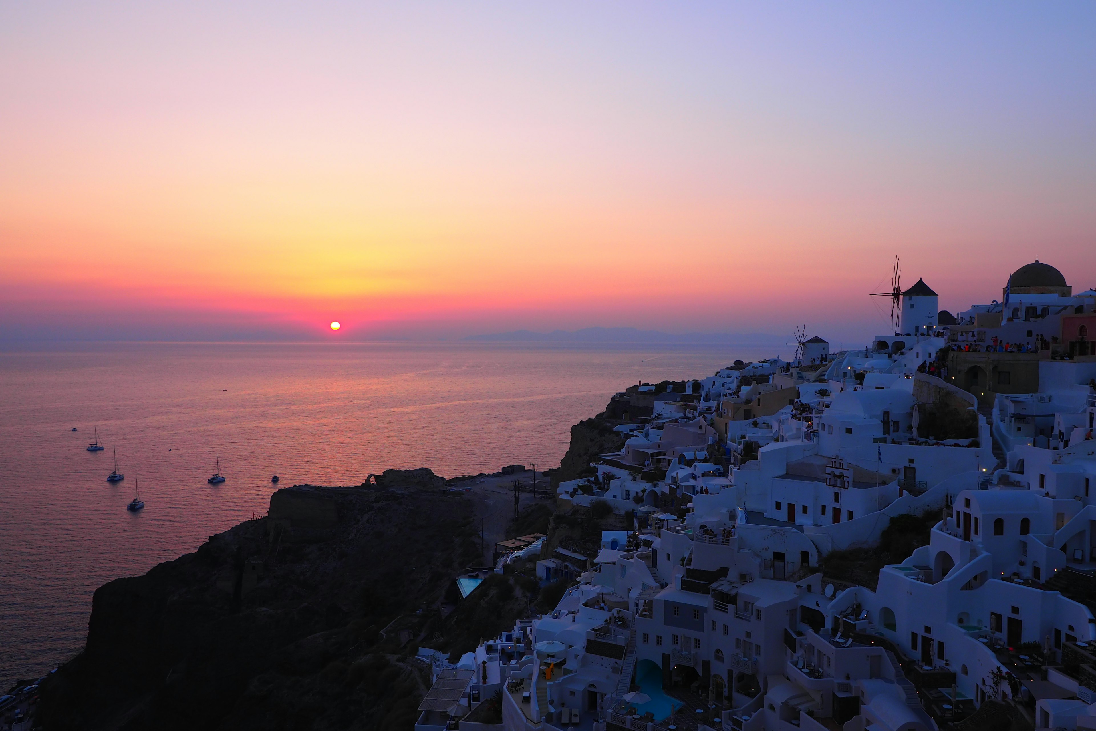 Coucher de soleil à Santorin avec des bâtiments blancs surplombant la mer