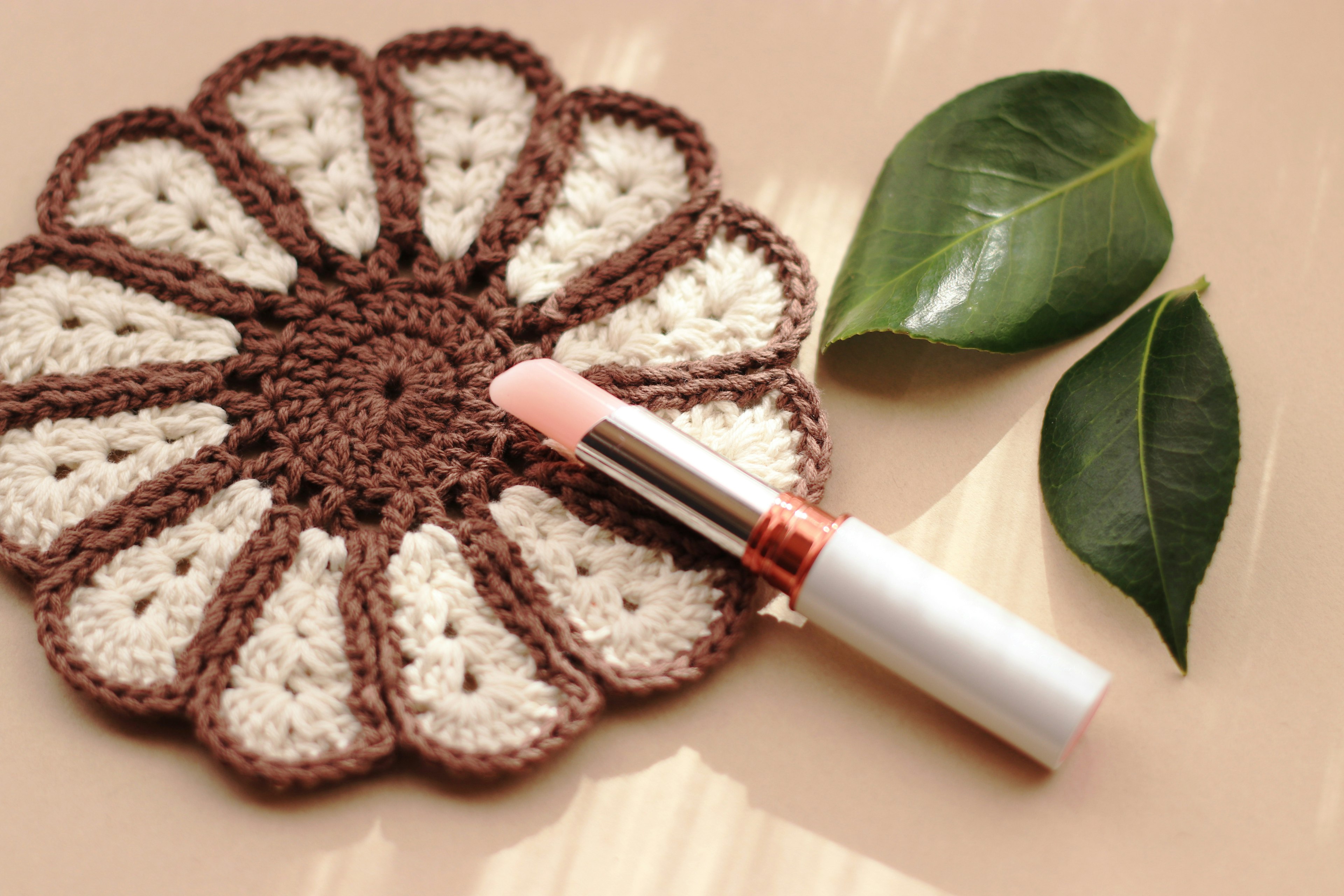 Sous-verre en crochet en forme de fleur avec du rouge à lèvres et des feuilles