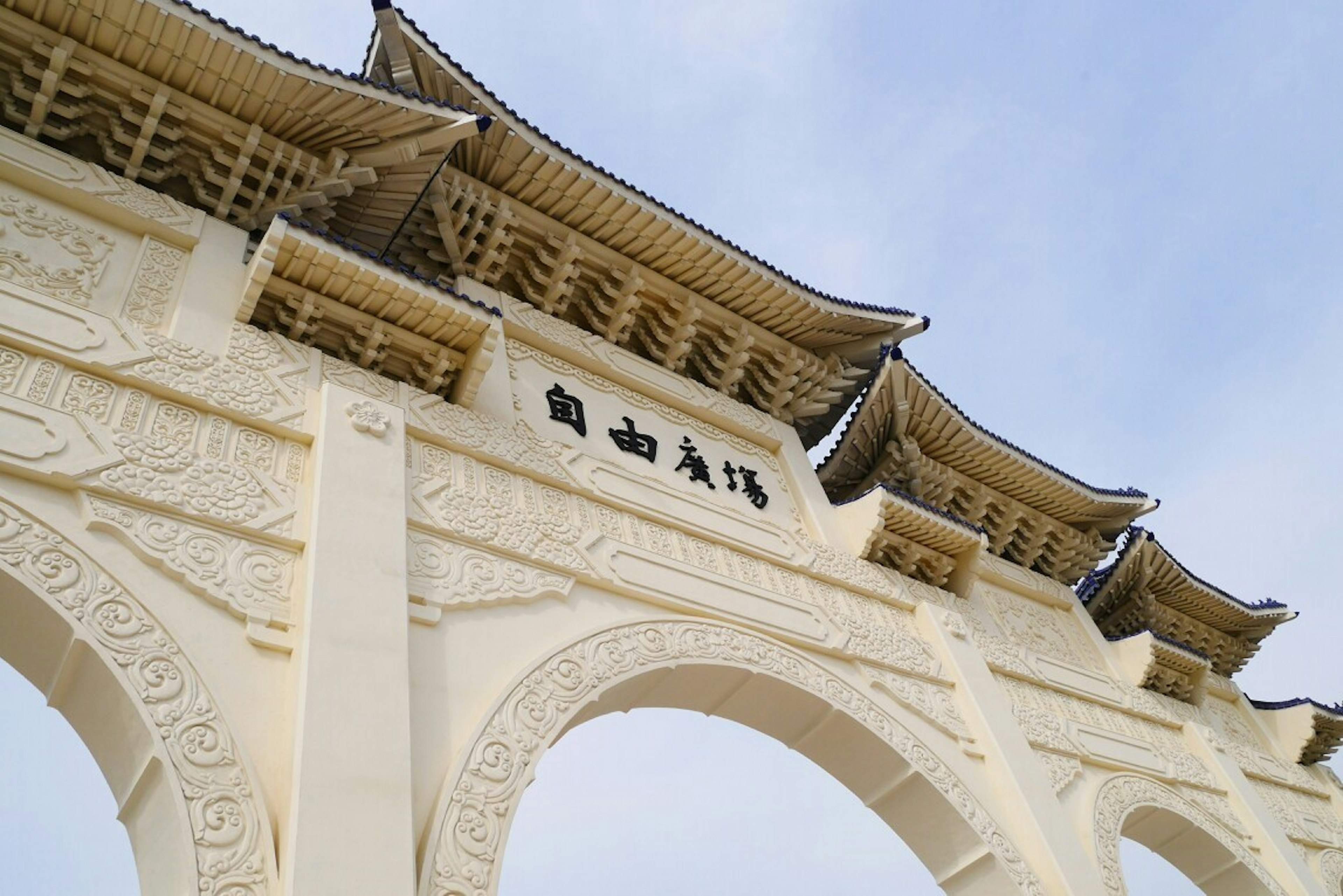 White arched gate with traditional roof design