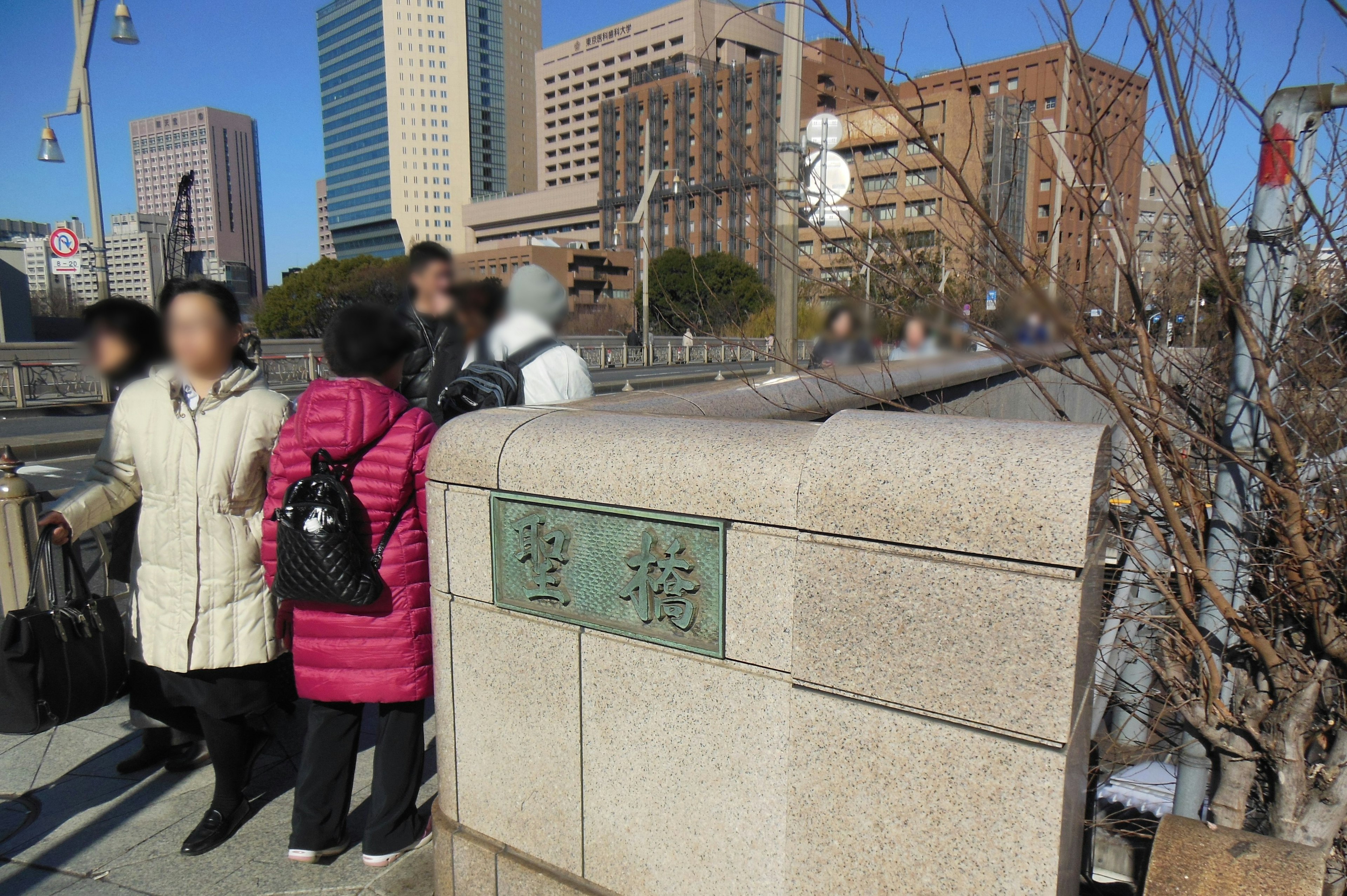 Des personnes rassemblées à la balustrade d'un pont admirant la skyline de Tokyo