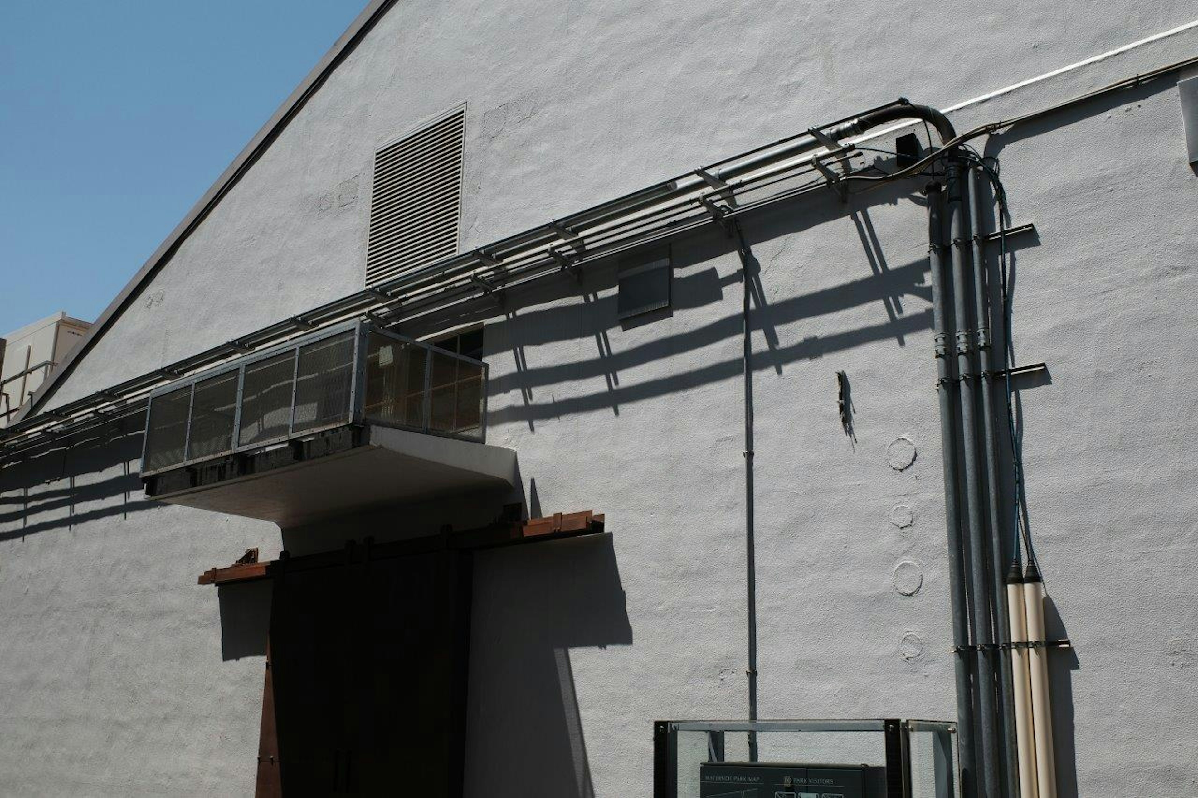 Air conditioning unit mounted on a white wall with visible piping