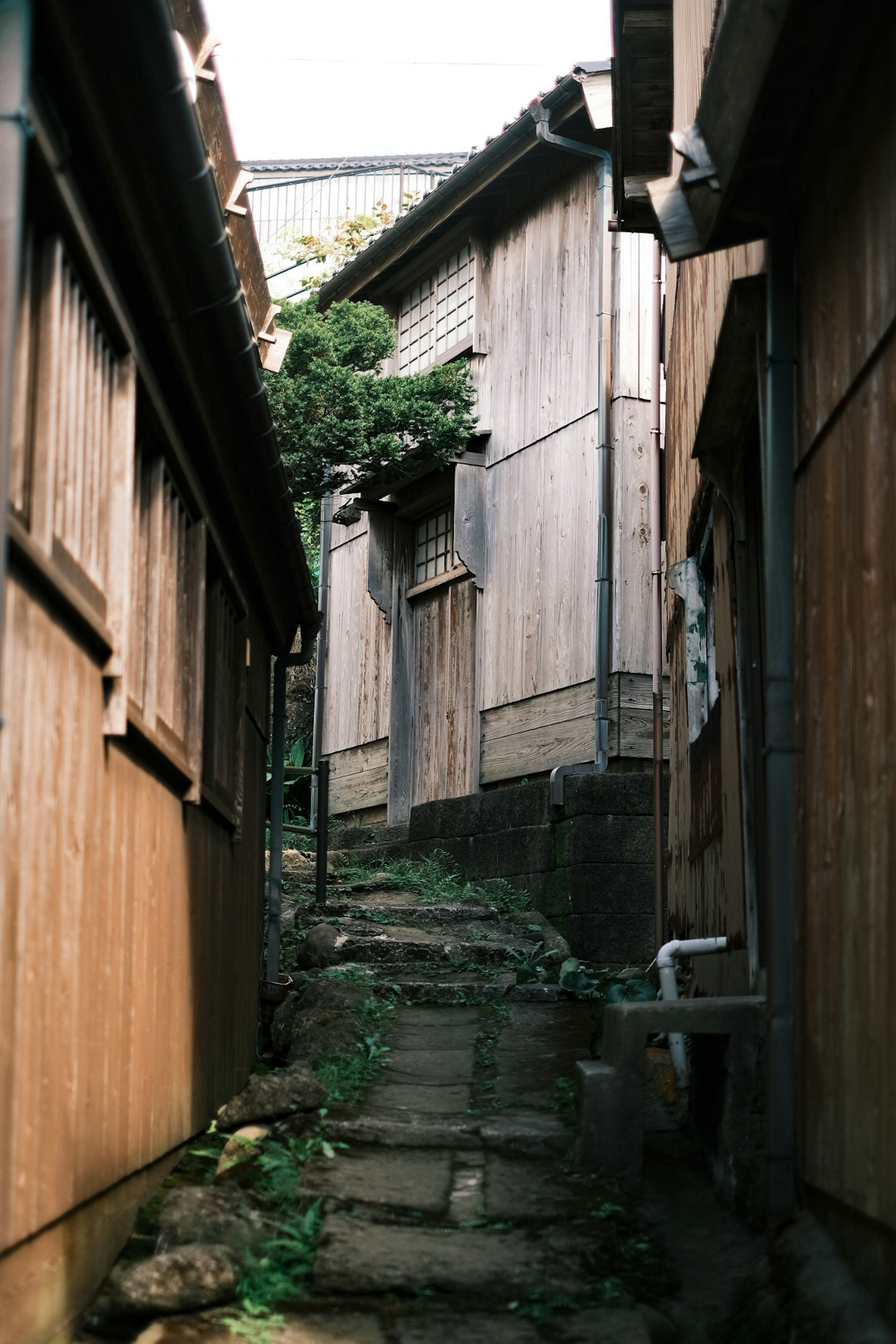 Callejón de piedra estrecho flanqueado por casas de madera