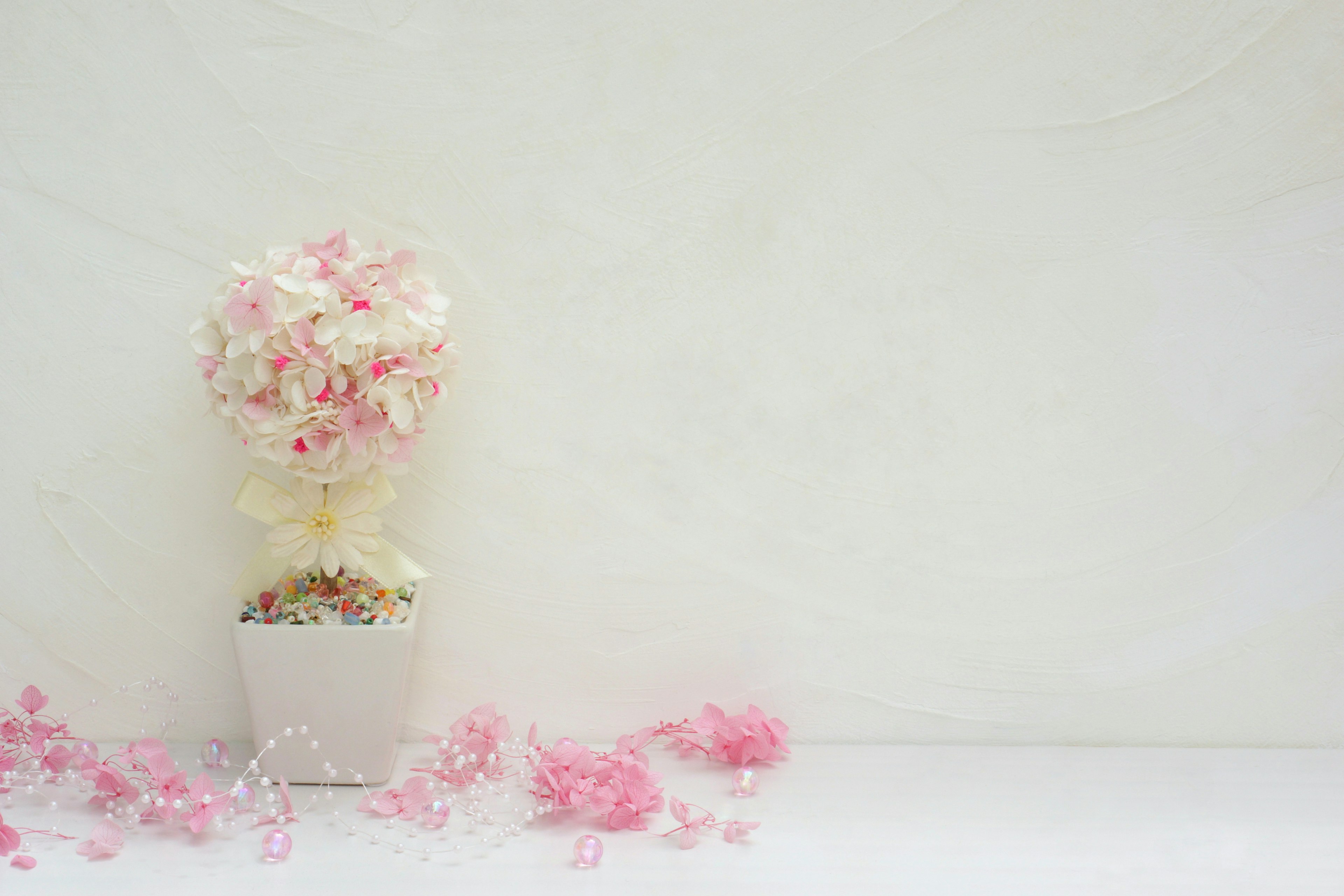 Arreglo de flores rosas y blancas en una maceta sobre fondo blanco