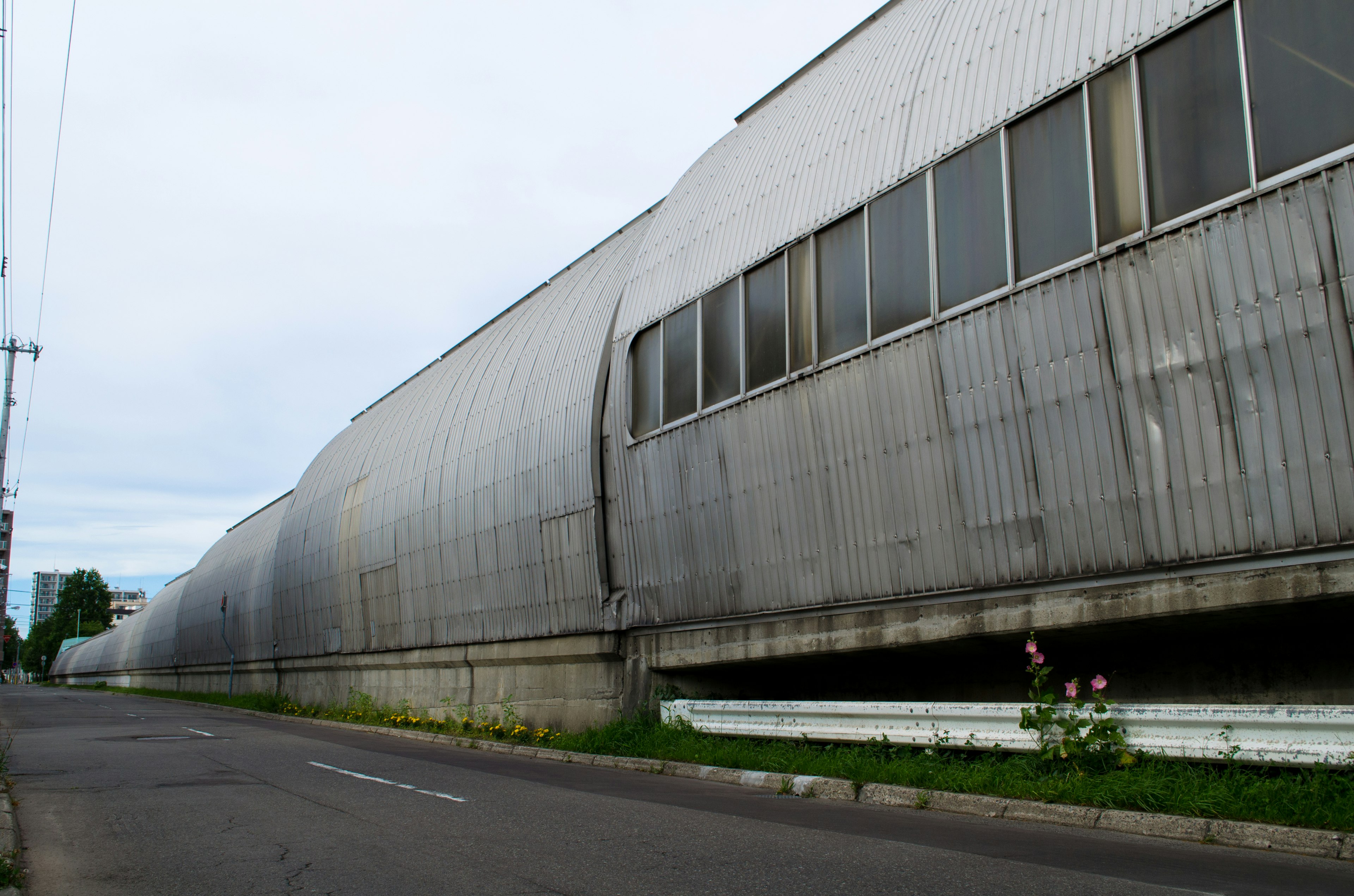 Long metallic building side stretching along the road