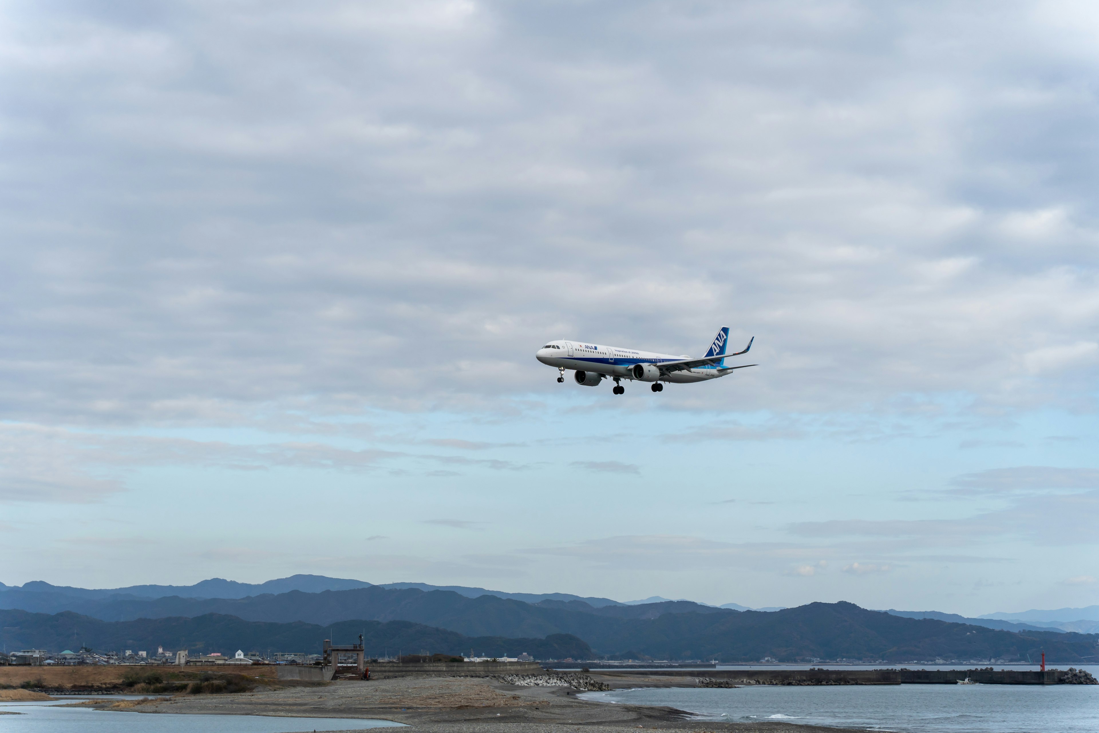 空を飛ぶ航空機が雲の中を進む風景